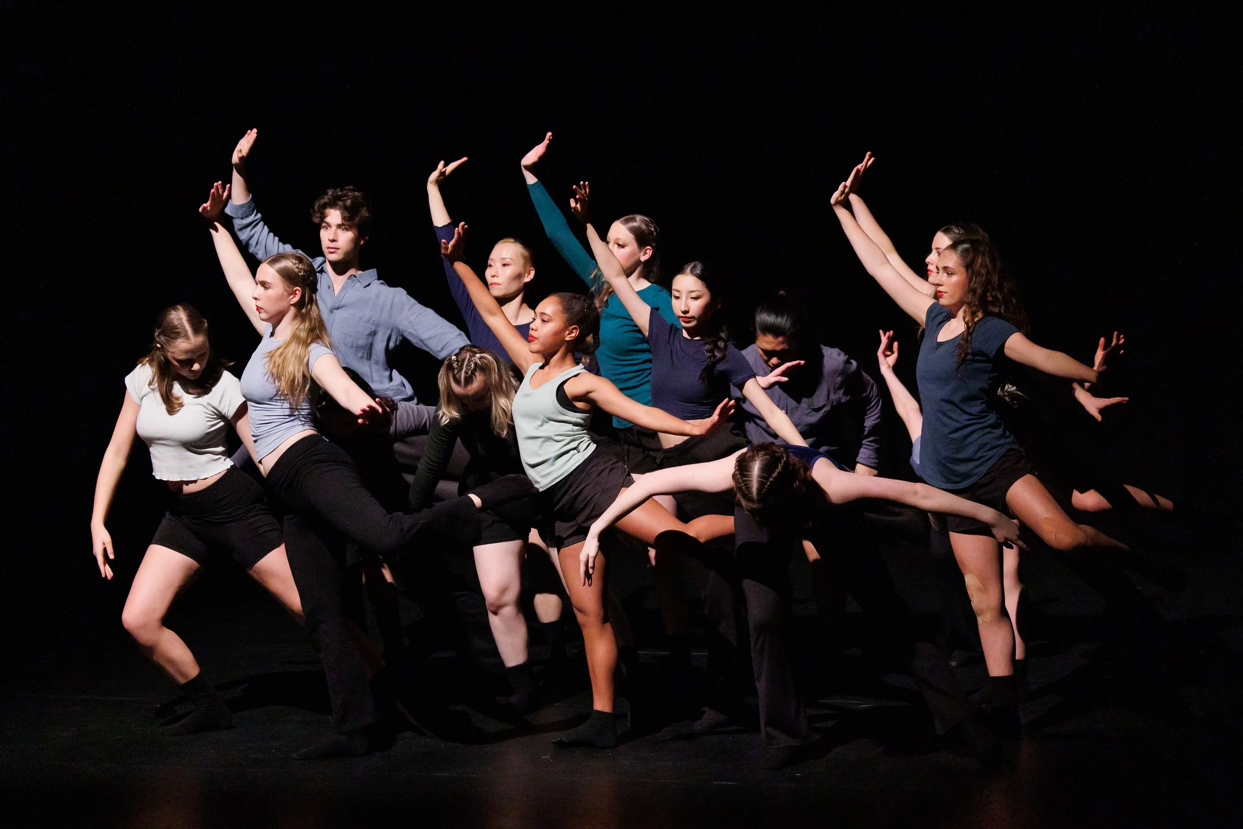 Advanced dancers together in attitude derriere looking out to stage right