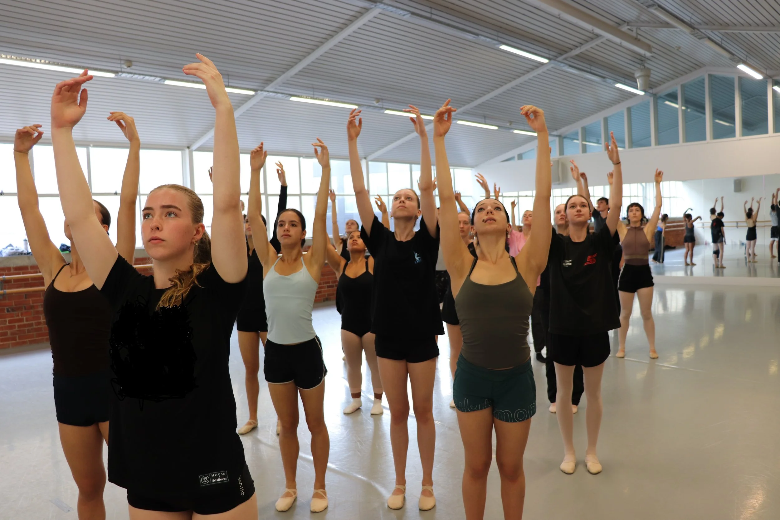 Collab-26 dancers rehearsing at Wellesley Studios daners standing in a corridor formation with arms reaching up and eyes looking up