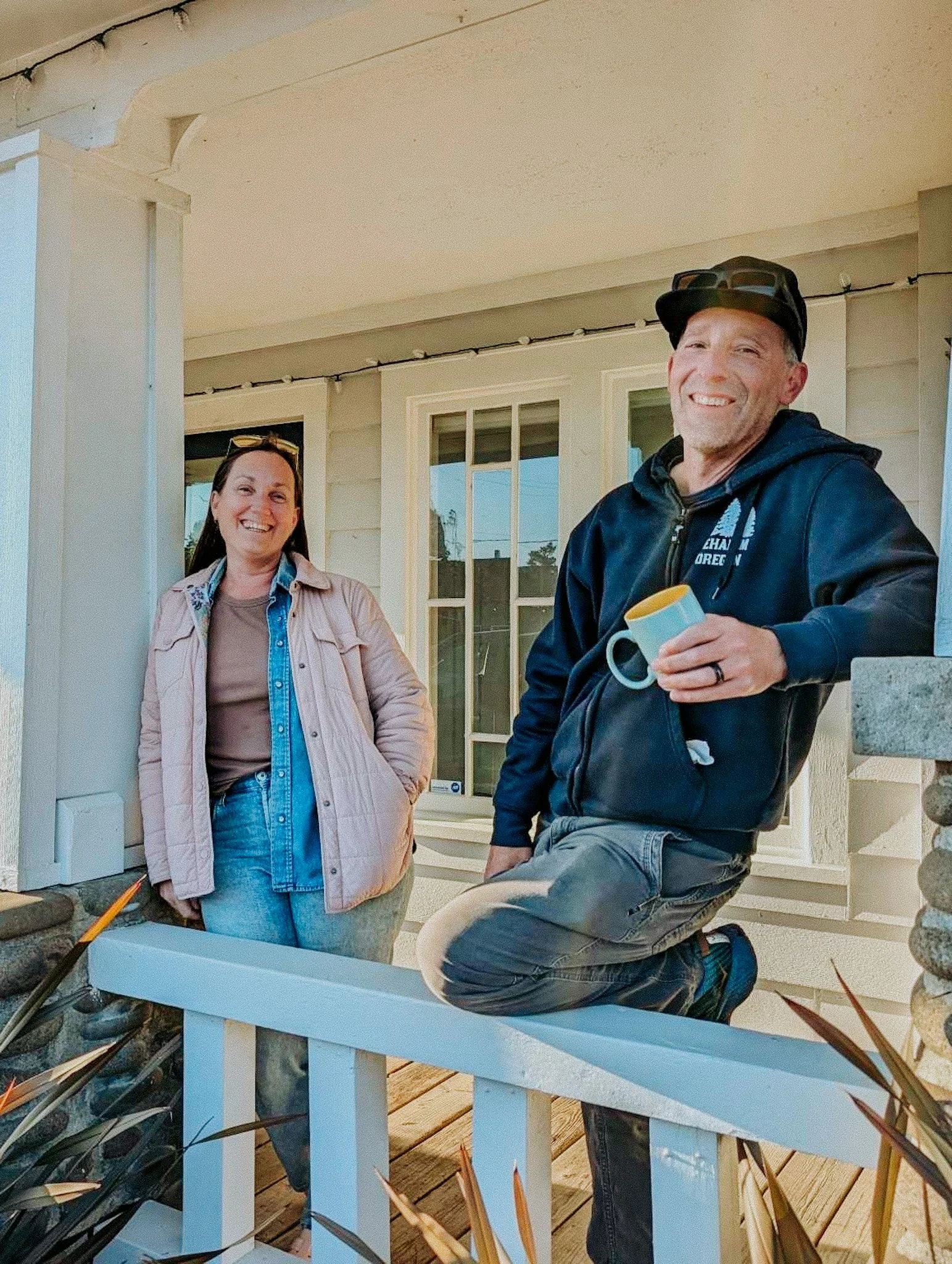 Man & woman on the porch of a coast shop in Manzanita, OR. Home to Perch Makers Table.
