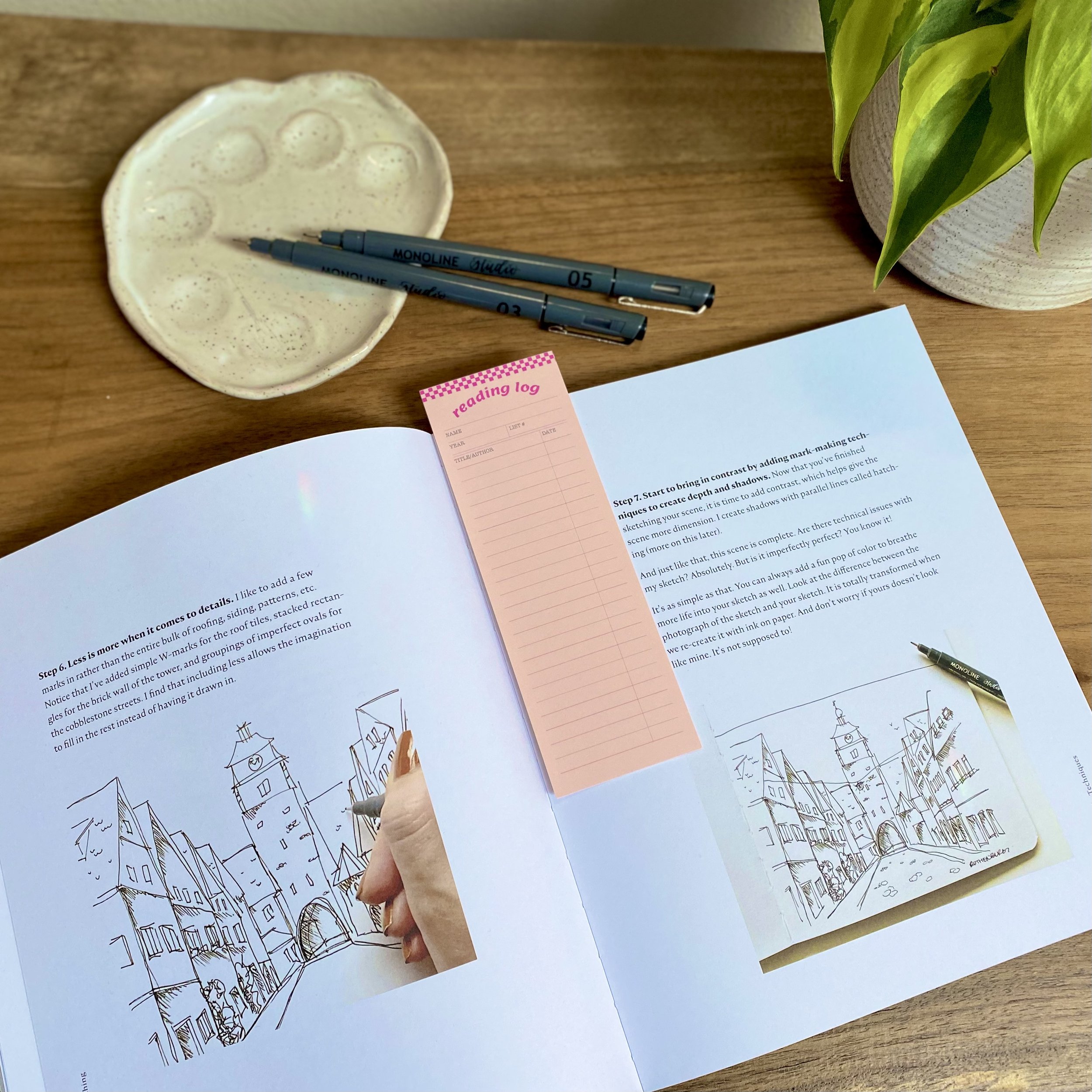 Checkered Reading Log bookmark placed inside 'Mindful Sketching' by Peggy Dean, marking a page for creative inspiration.