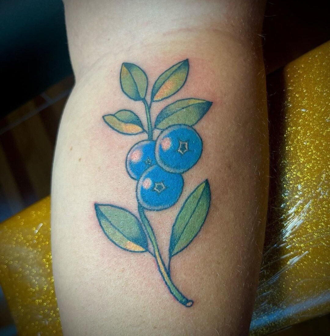 Blueberry branch tattoo on the top of the left