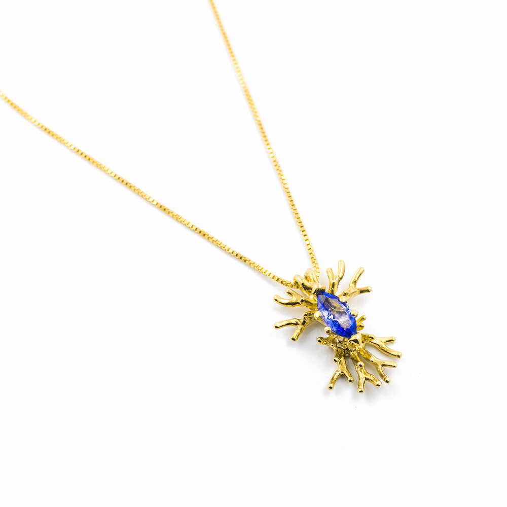 18ct yellow gold branches surround and hold a marquise cut tanzanite. Luke Maninov