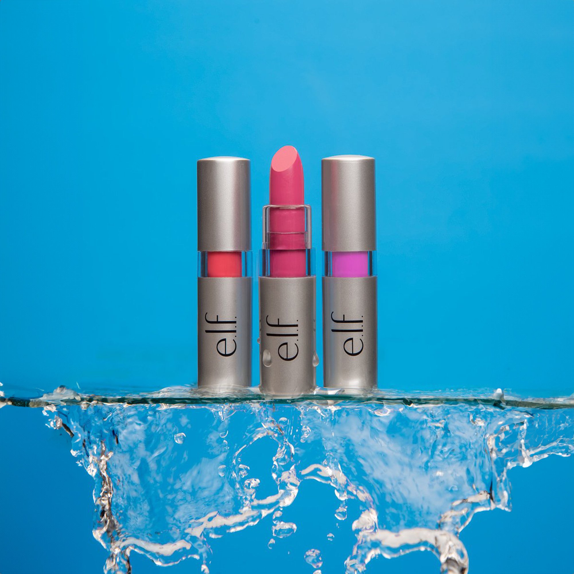 lipstick on a glass shelf with water flowing off the edge against a light blue background 