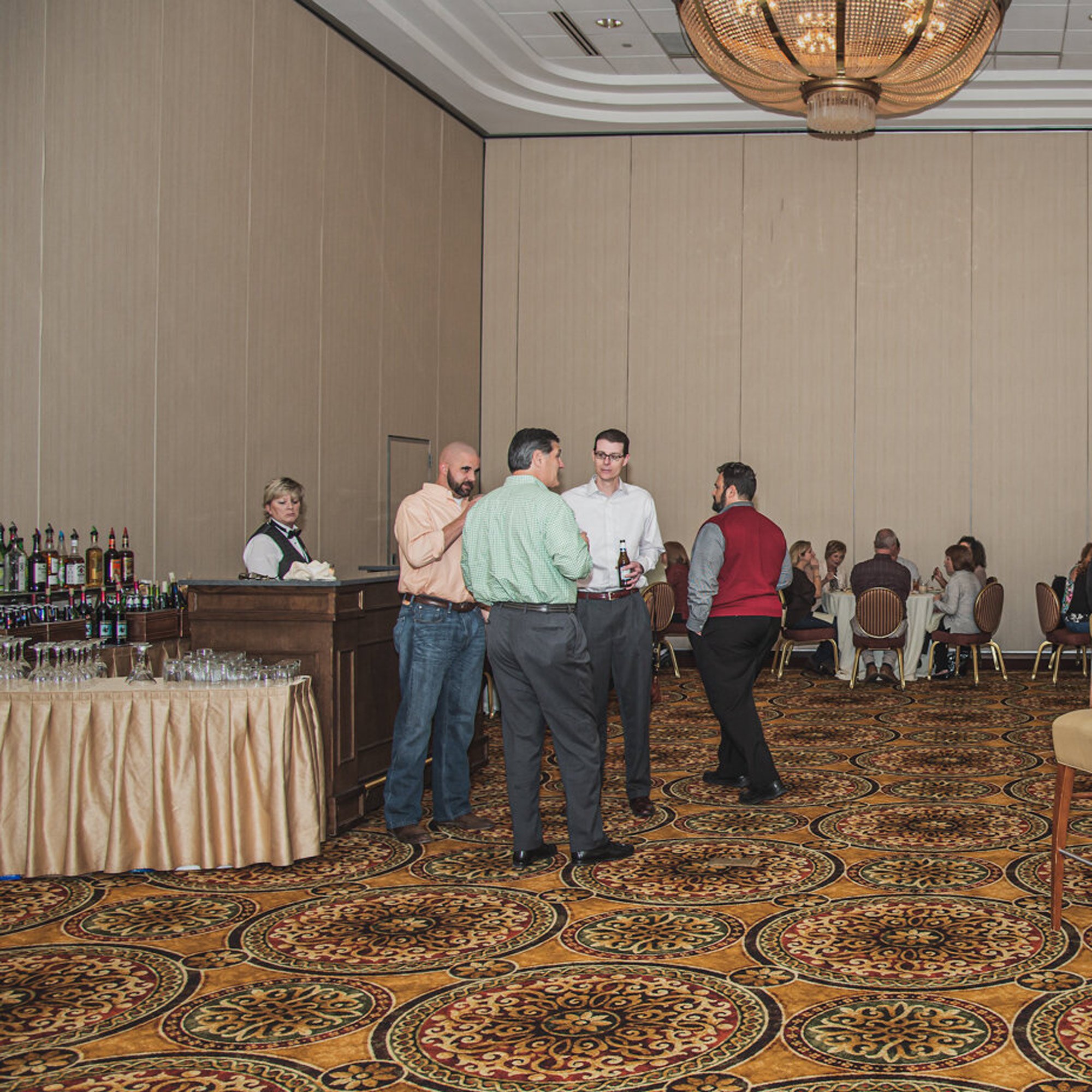  people socializing in a ball room at a corporate event 