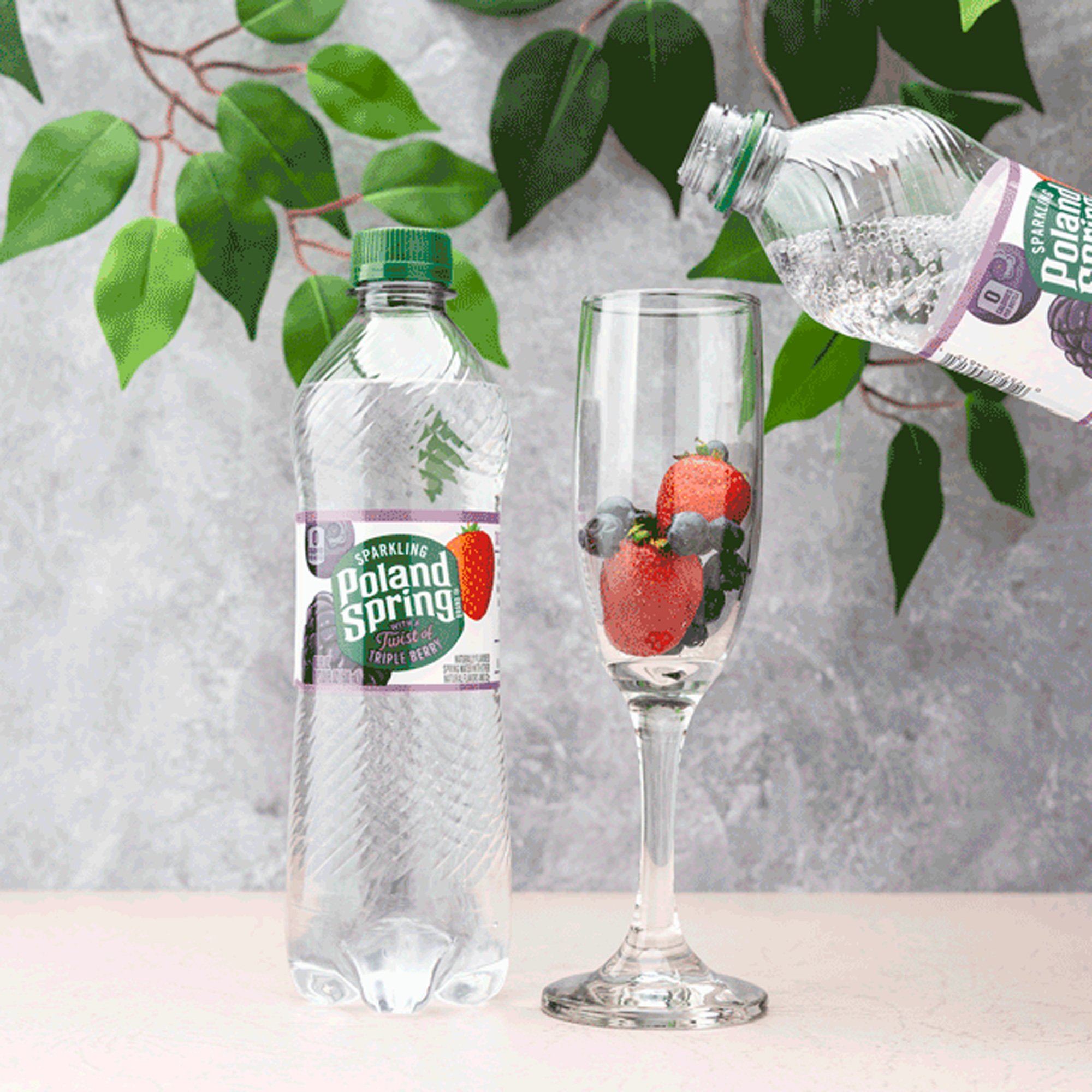  Beverage pour photography on a styled background of a gray stone wall and green leaves 