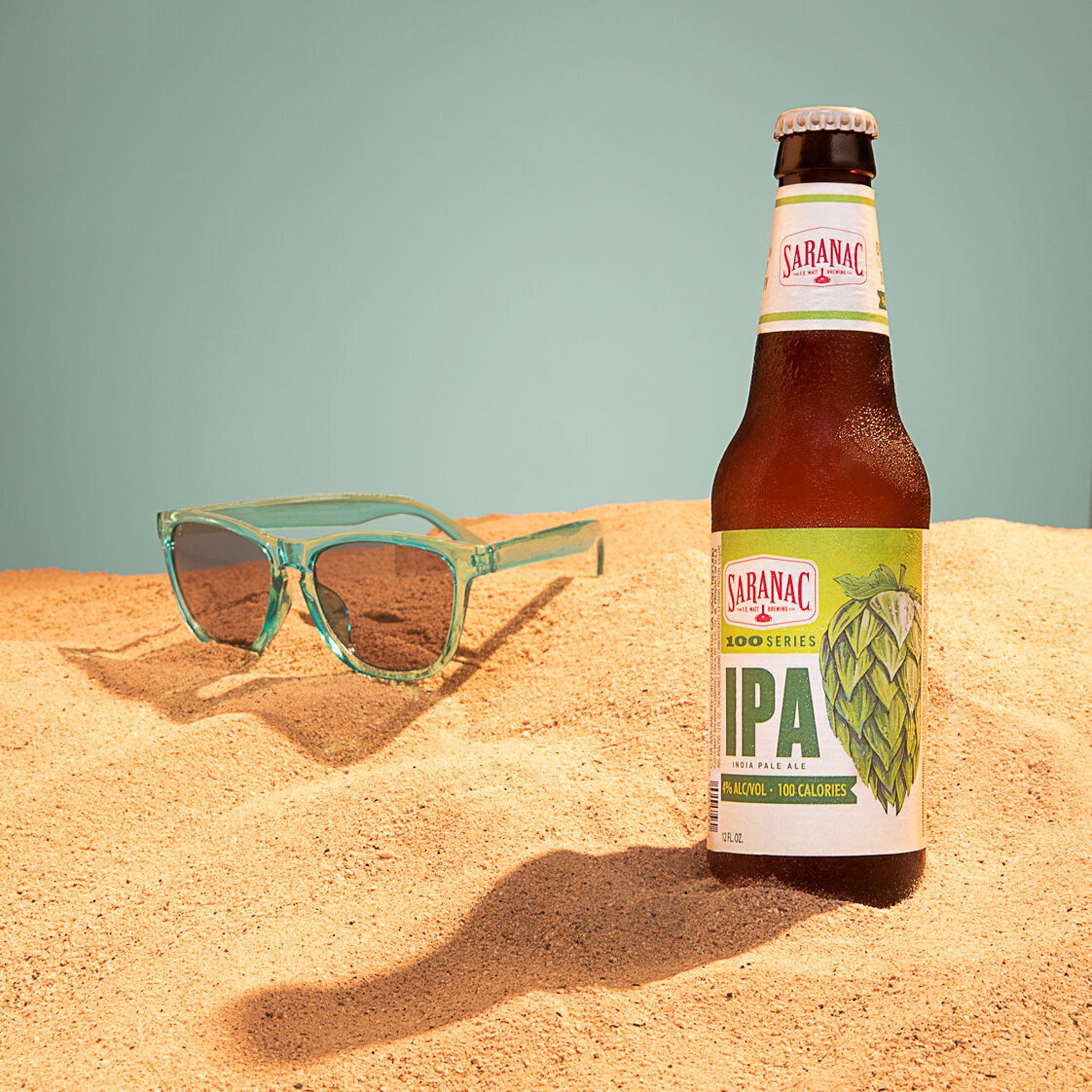  studio set design of a beach with sunglasses and a bottle of Saranac beer  