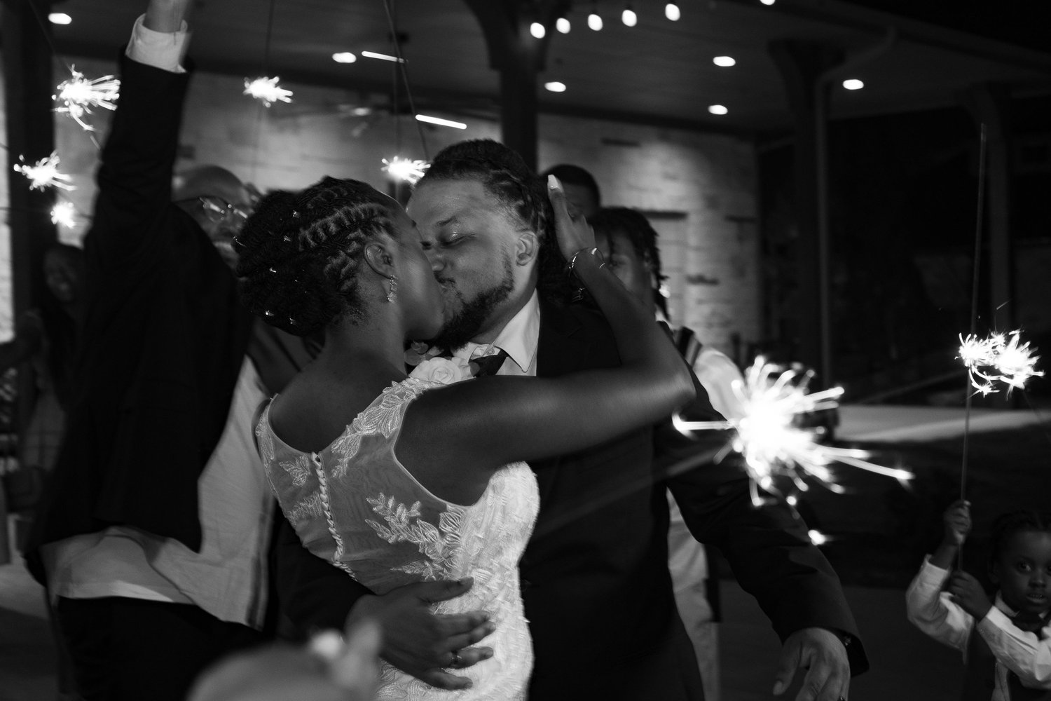Newlyweds kissing during their sparkler exit
