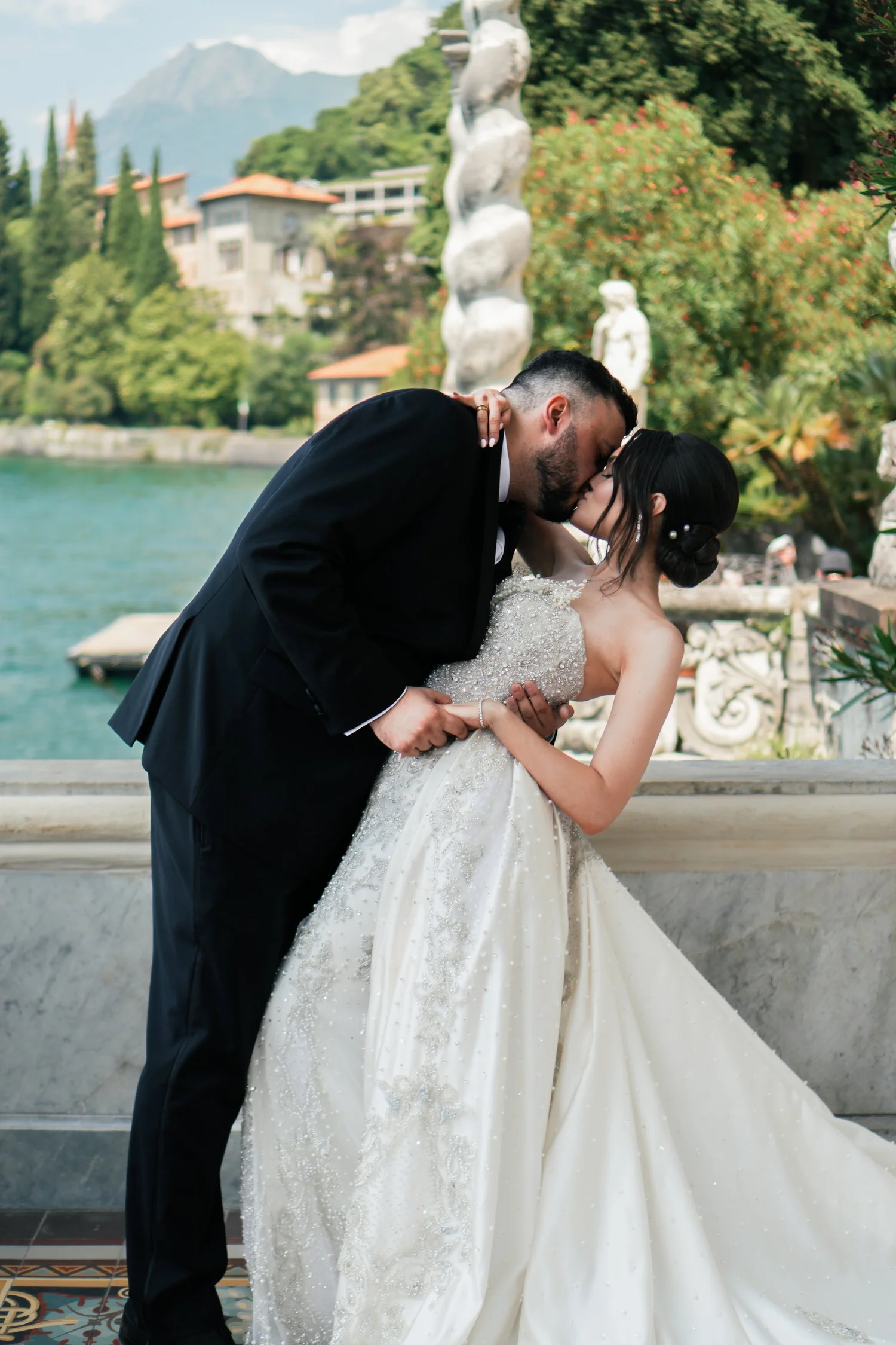 Newlyweds kissing beside Lake Como