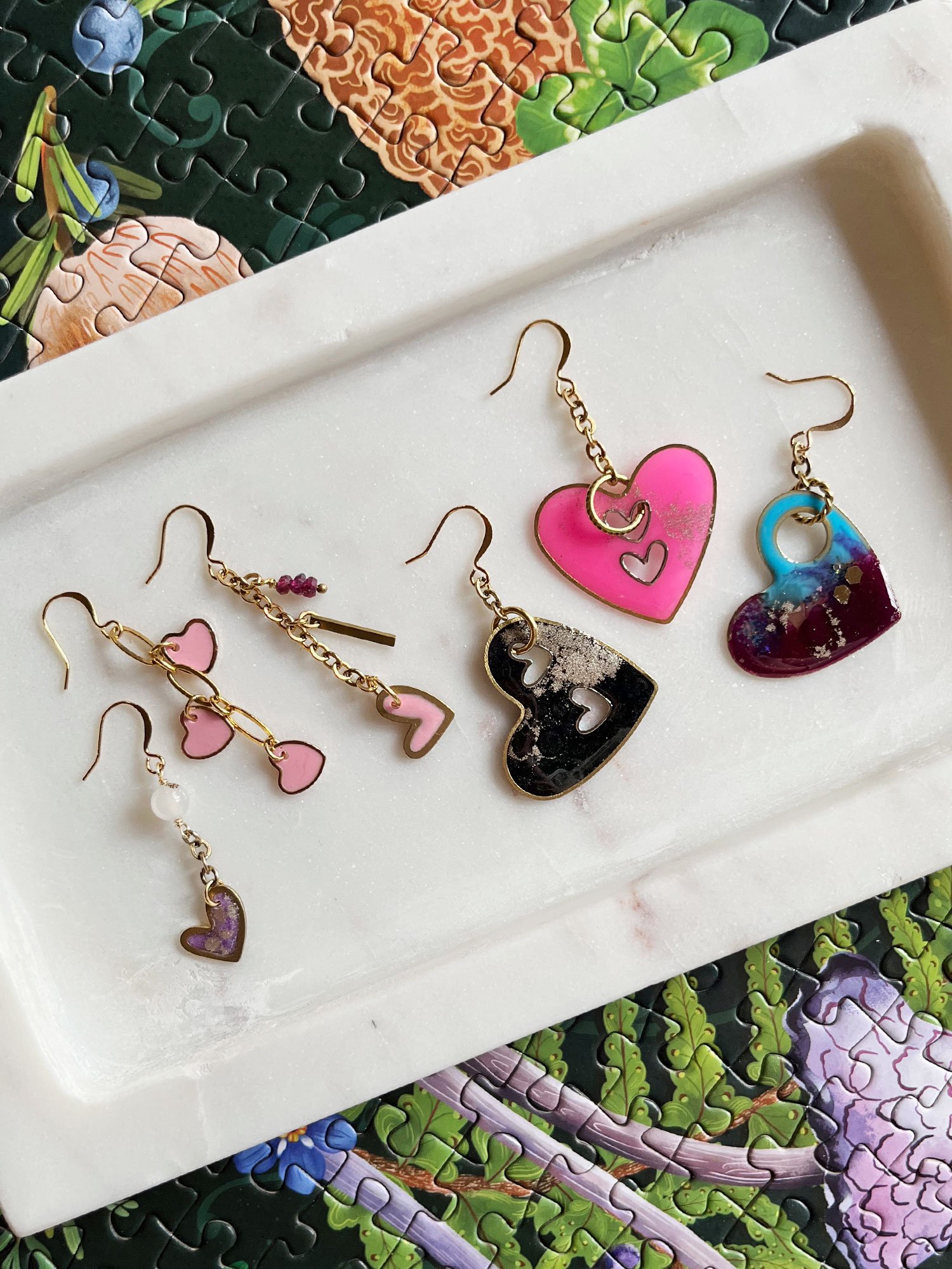 White marble tray with a group of heart earrings. (Copy)