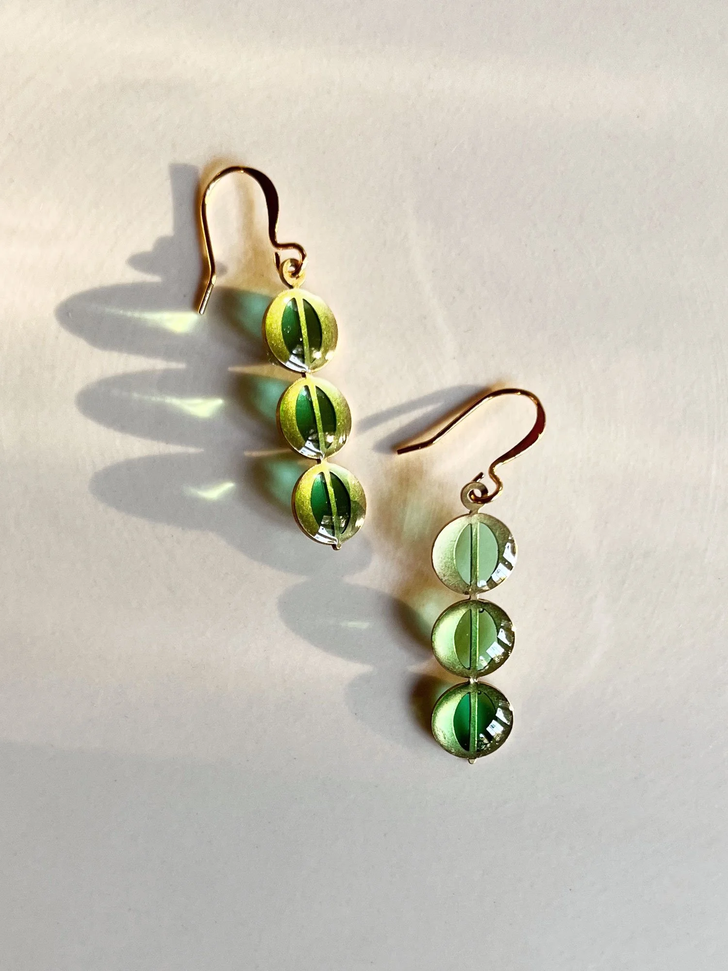 Juno Earrings in Green reflecting in the sun.