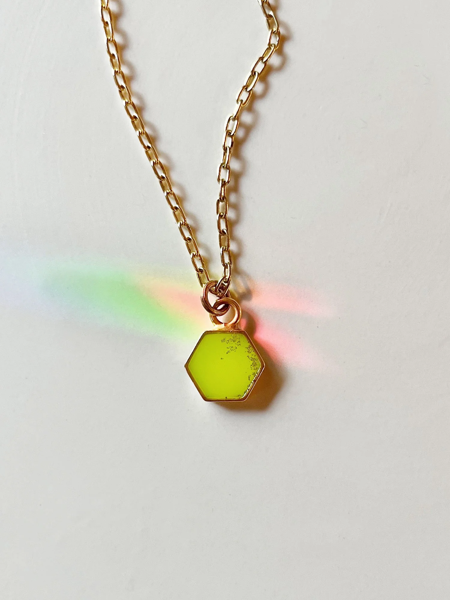 Gold hexagon pendant necklace in lime green with thicker cable chain.