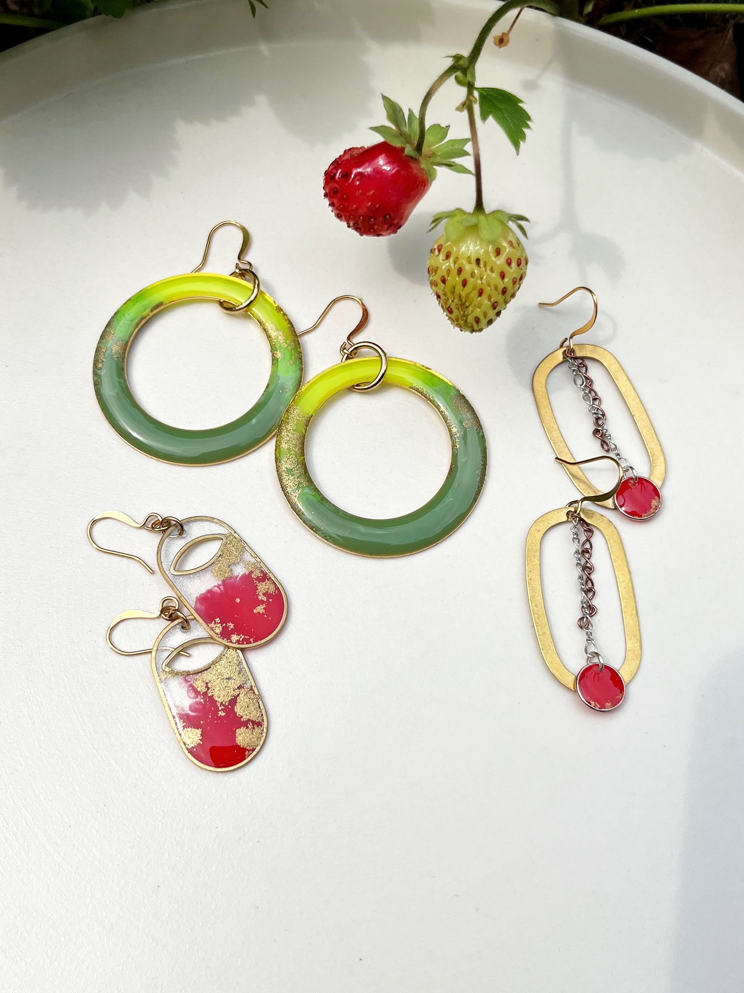Three pairs of earrings in reds and greens with strawberries