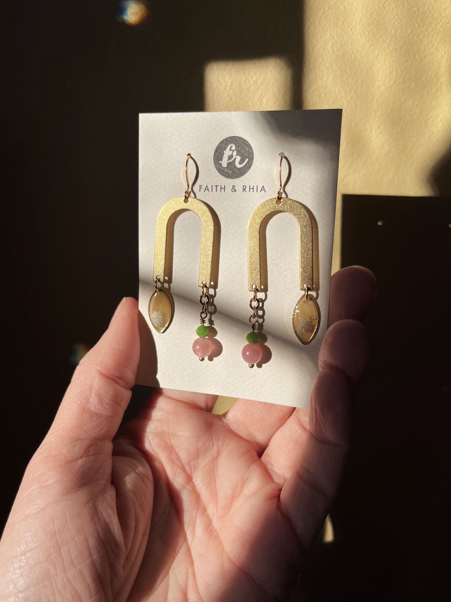 A hand holding a Faith & Rhia Jewelry card with the Nena Earrings