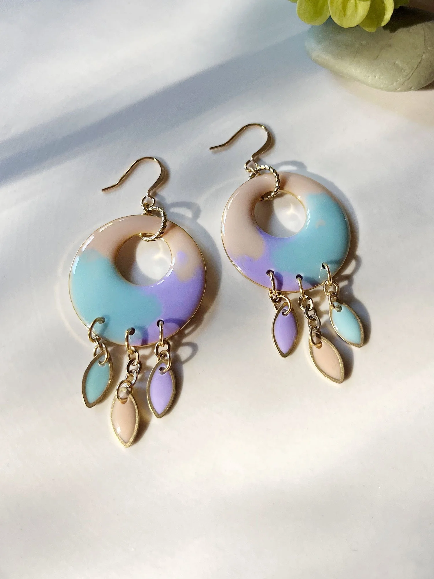 Circle hoops in aqua, lavender, and beige in strong sunlight