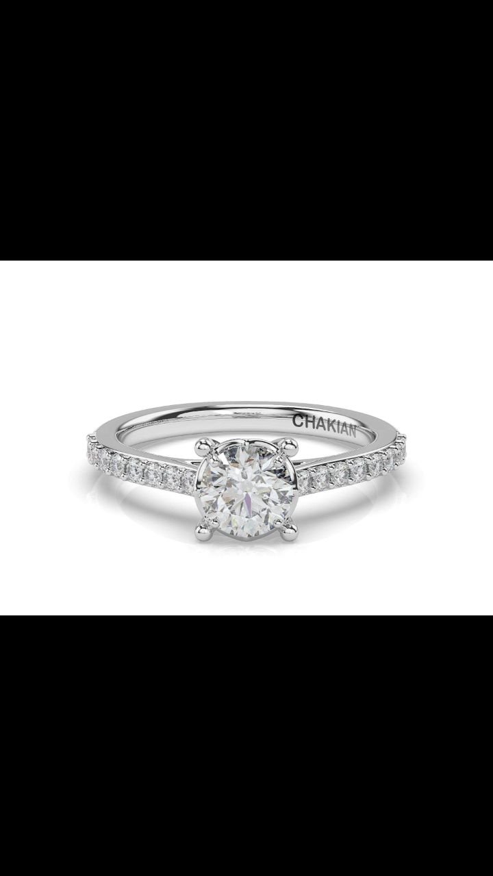 ✨ A timeless promise, set in brilliance ✨
This elegant solitaire engagement ring by CHAKIAN features a dazzling round-cut diamond embraced by a cathedral setting and accented by a shimmering Shared Claw-Set Diamonds. A delicate fusion of classic beau