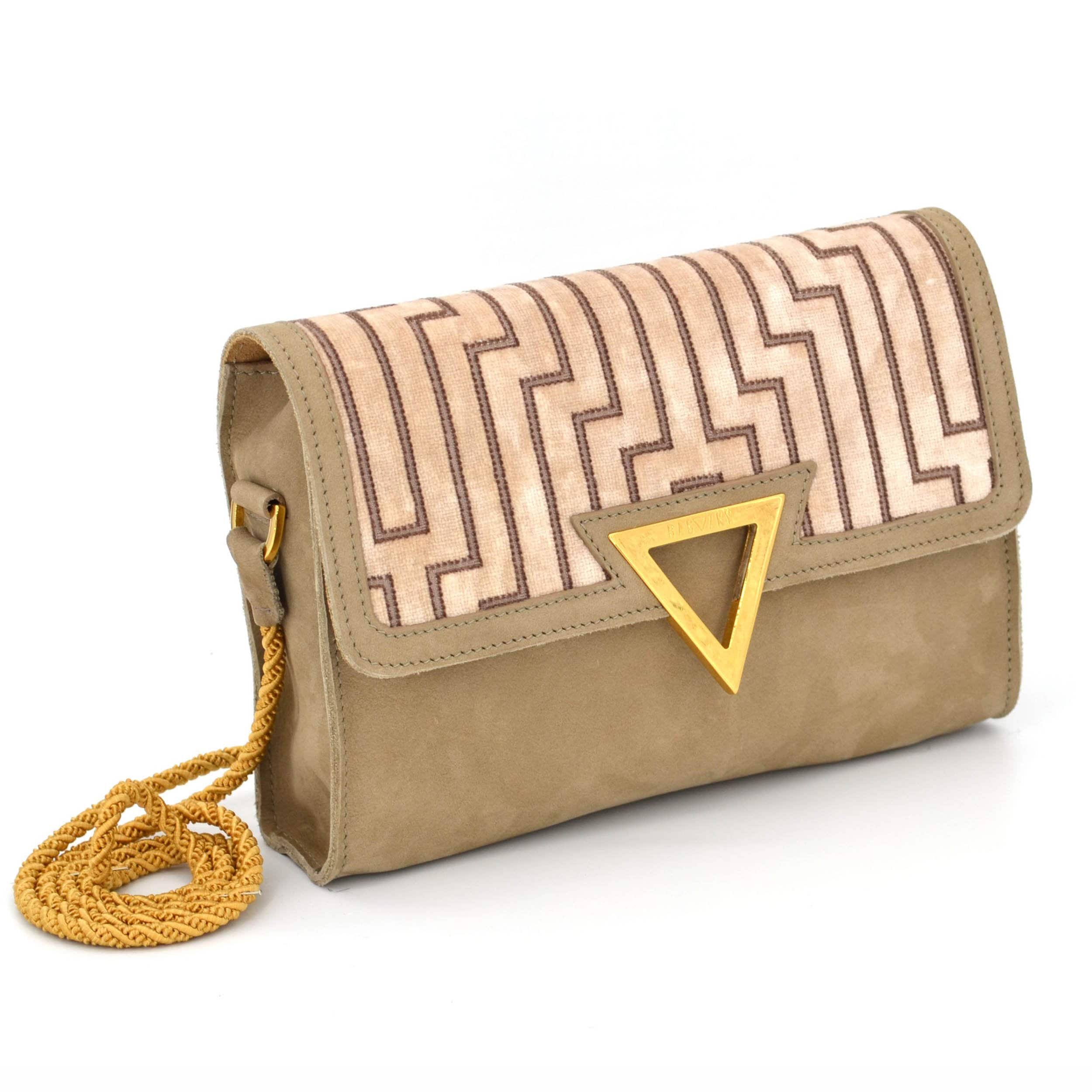 Side view on the sand coloured suede Tapezzeria Bag. You can see that is has a side panel to create space. All of your daily belongings will fit in, like portemonee, cellphone, keys and some make up.