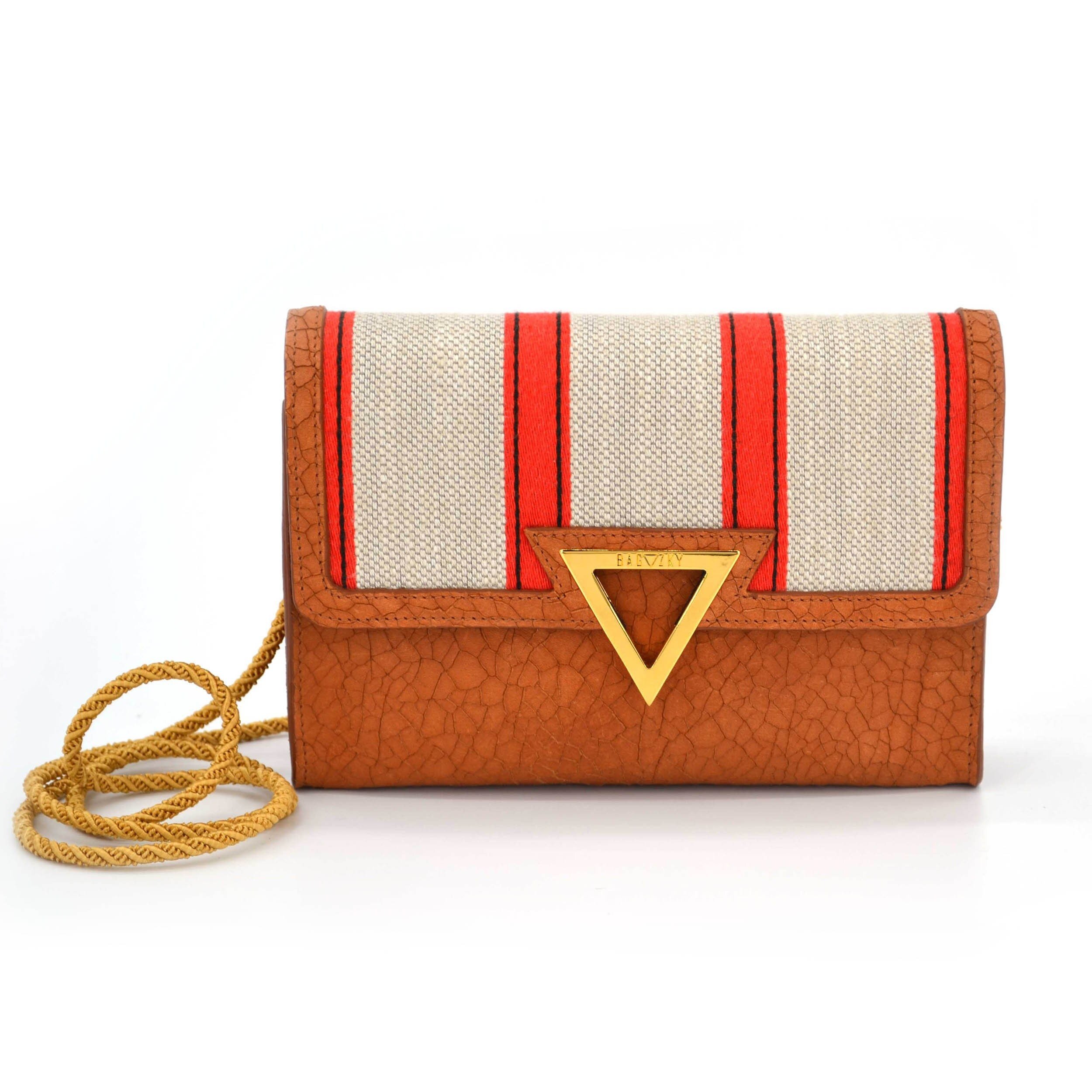 Front view of the small brown leather bag, which is combined with upholstery fabric. The fabric is beige and has some red stripes on it.