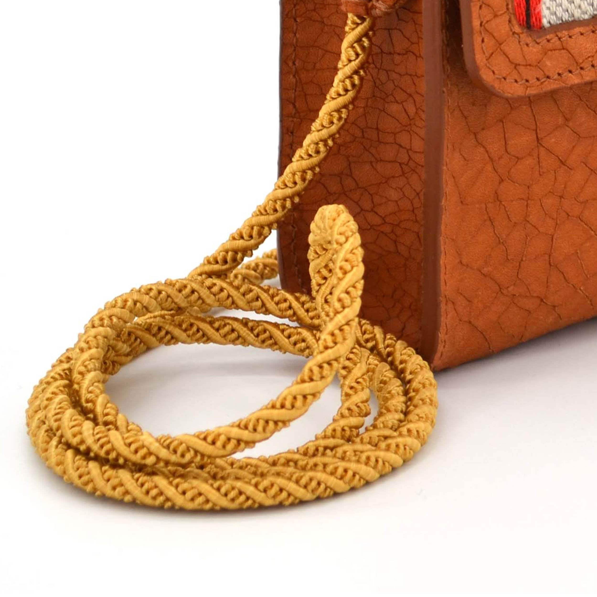 Detail of the hand turned passement cord. It´s a so called pearled cord, twisted from three golden strands.