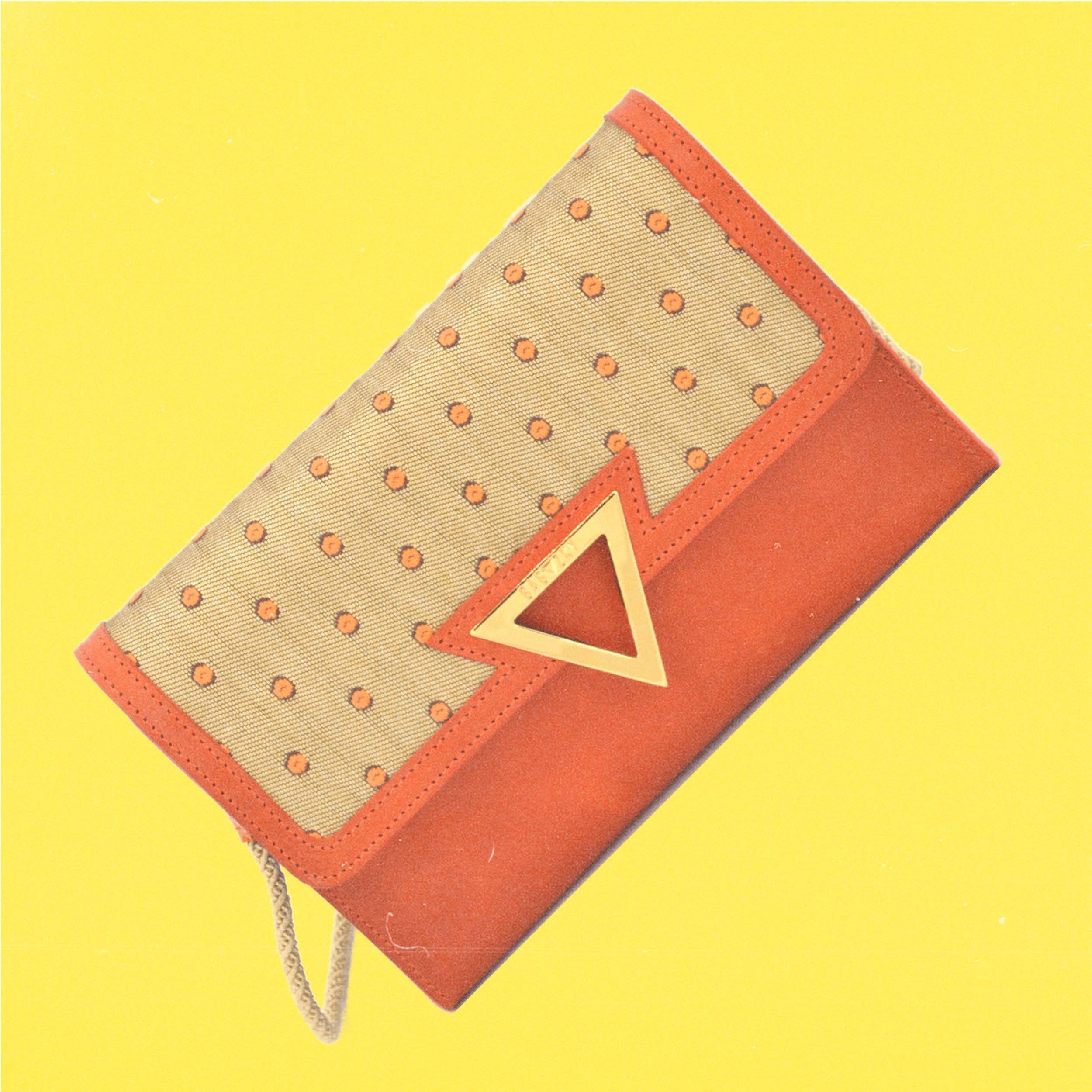 Apricot Moodpic, that shows the orange leather clutch against a yellow background.