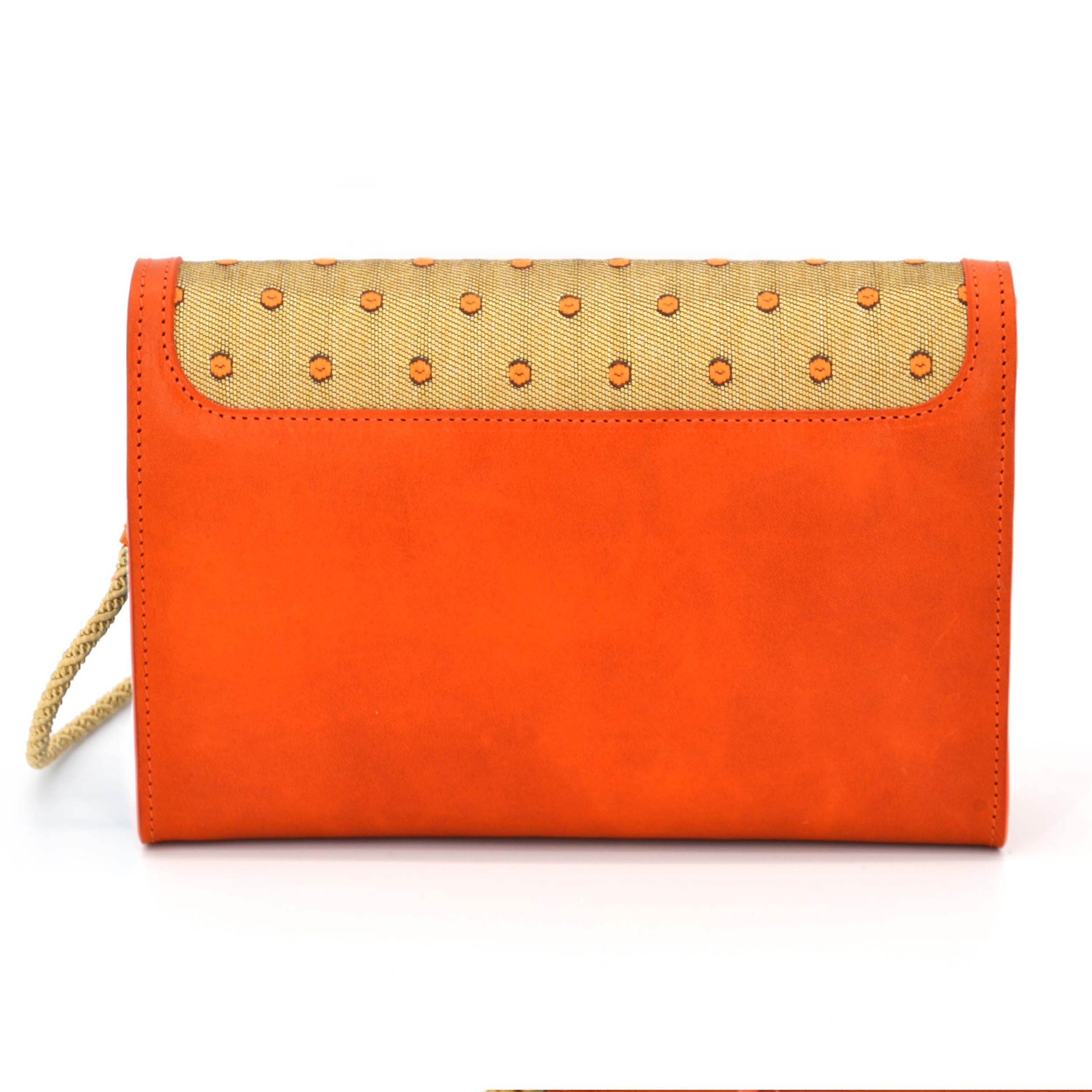 Back view of a small orange handbag. It is combined with golden fabric, which has orange dots on it.