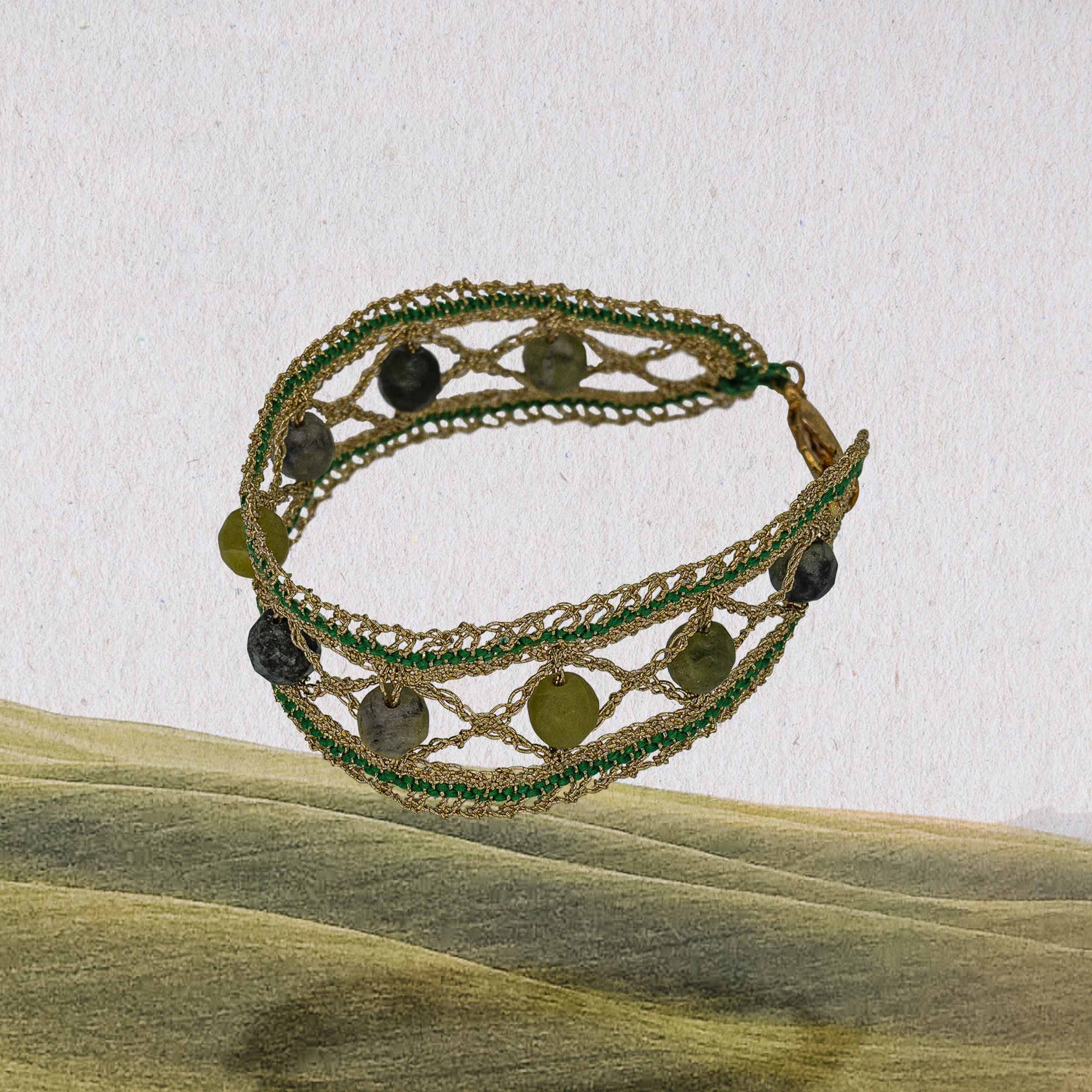 The large stone beads in various shades of green symbolize the diverse nature of Tuscany and ground the viewer. The shiny gold lurex gives the bracelet that special something extra.