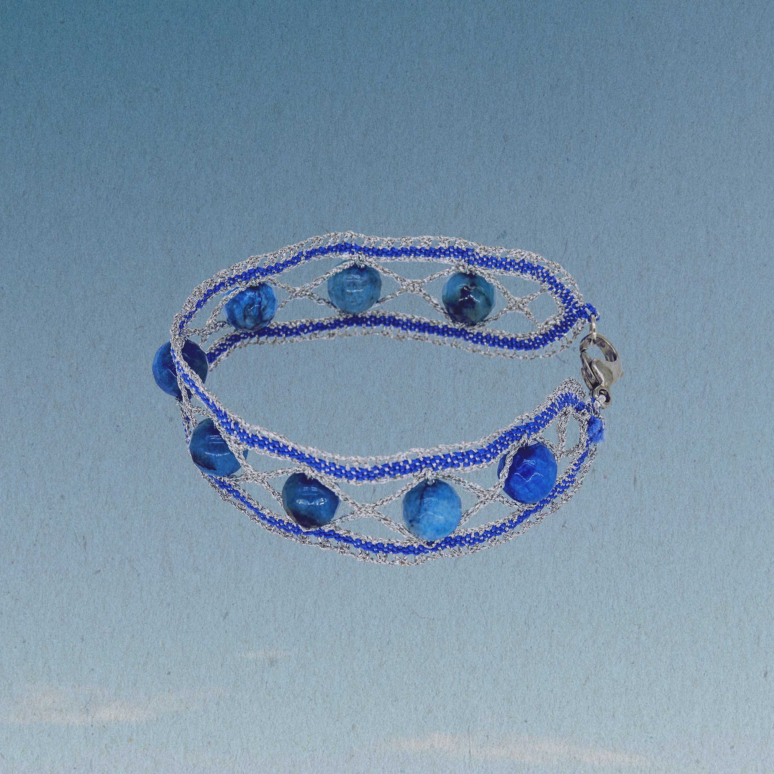 Silver lurex thread and ultramarine embroidery thread, artfully bobbin lace, provide the frame for the beautiful blue stone beads in all the colors of the ocean.