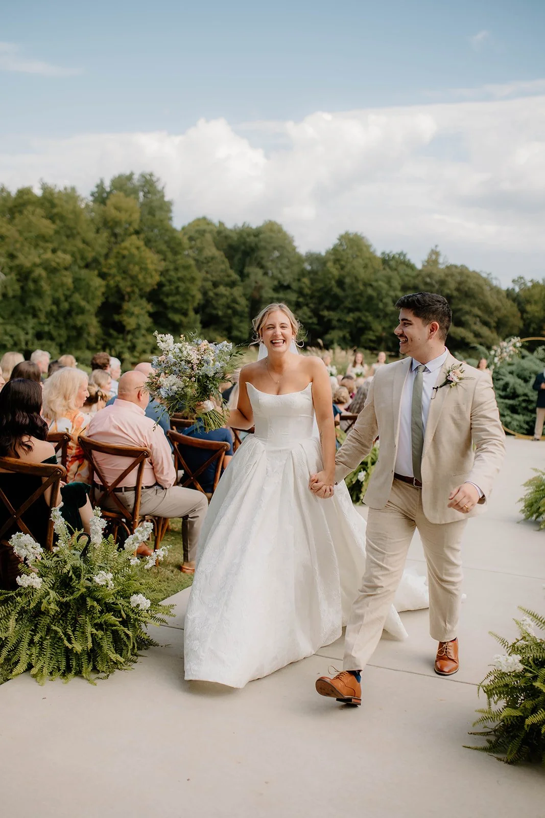 Couple walking back up the aisle surrounded by cheering guests
