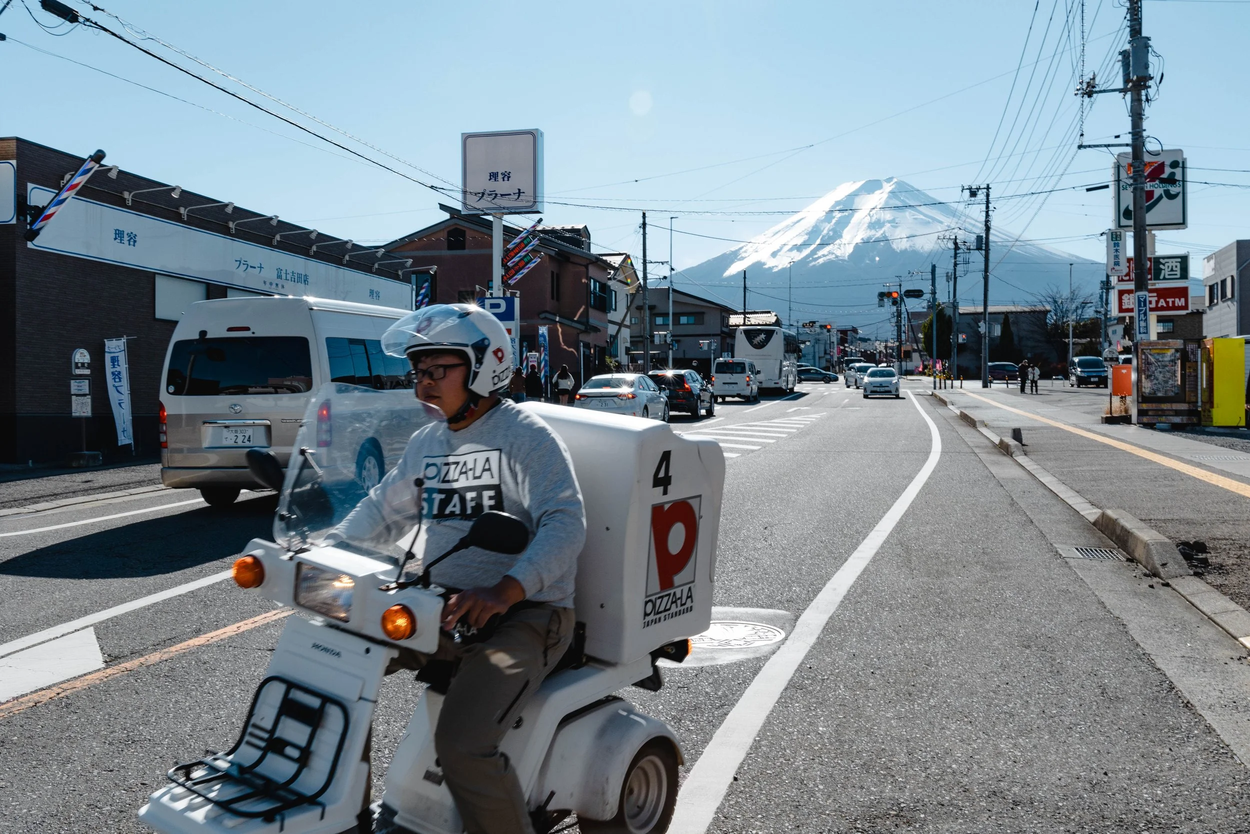 picture of Mt. Fuji in the background with a pizza delivery motorbike in the foreground