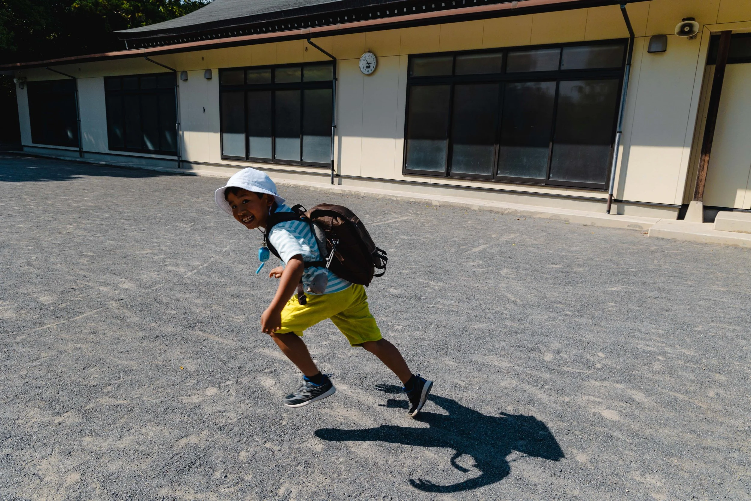 Kid running in the spaces around the temples in Kamakura.