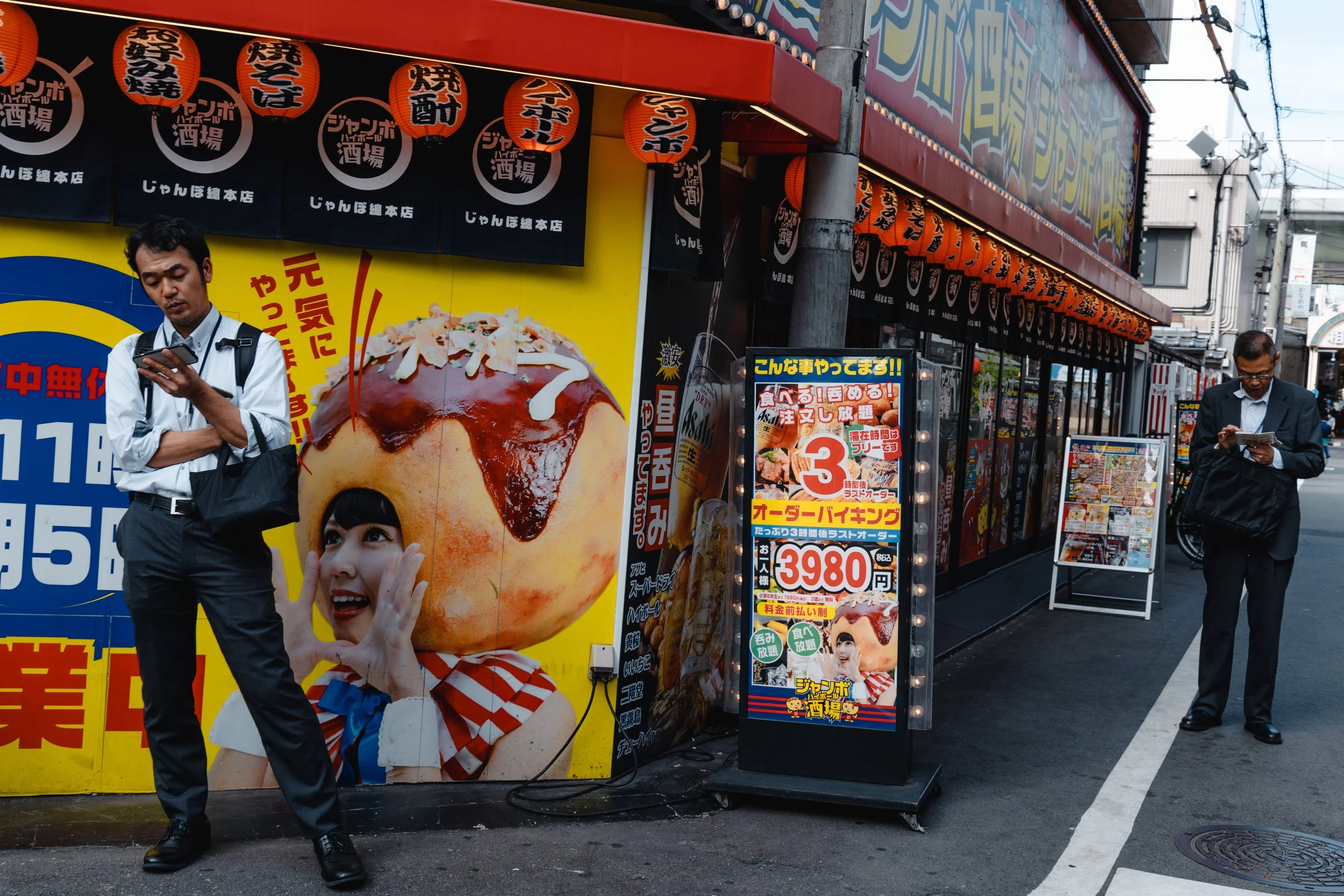 people on their phones on the streets of Namba, in Osaka
