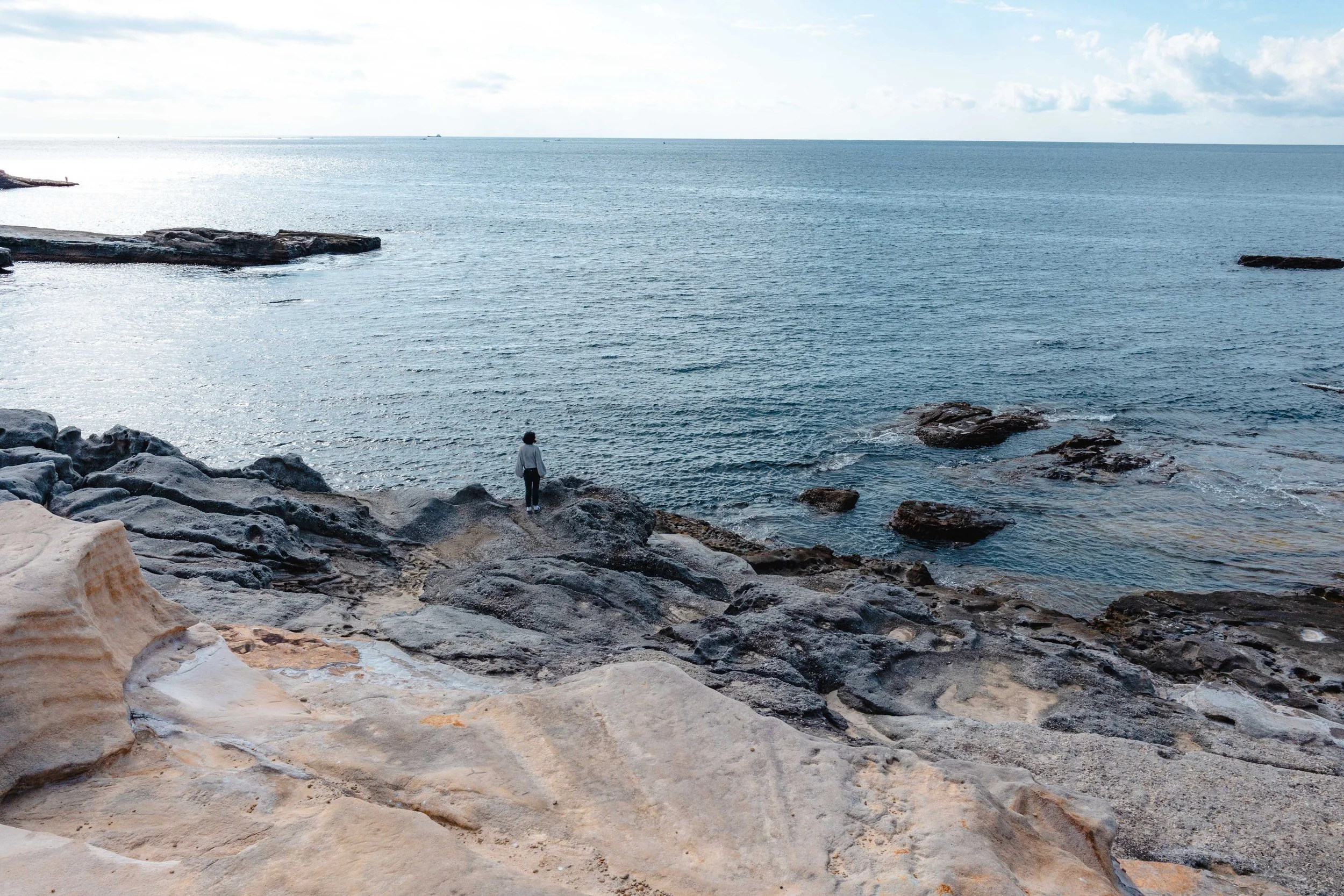 Girl contemplates the ocean from the Senjojiki Rock Plateau