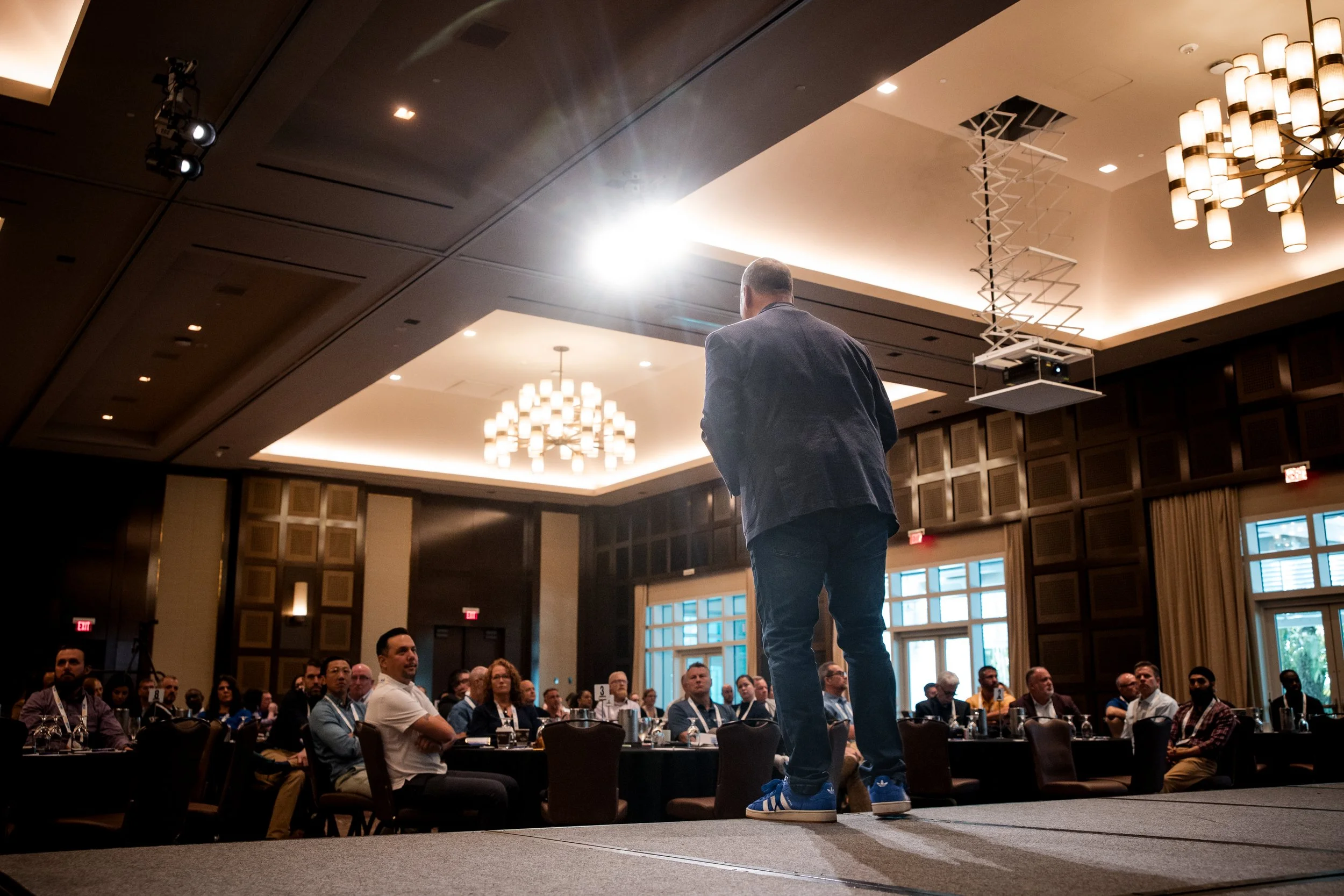 A keynote speaker commands the room, delivering a compelling message that anchors the event’s central theme.