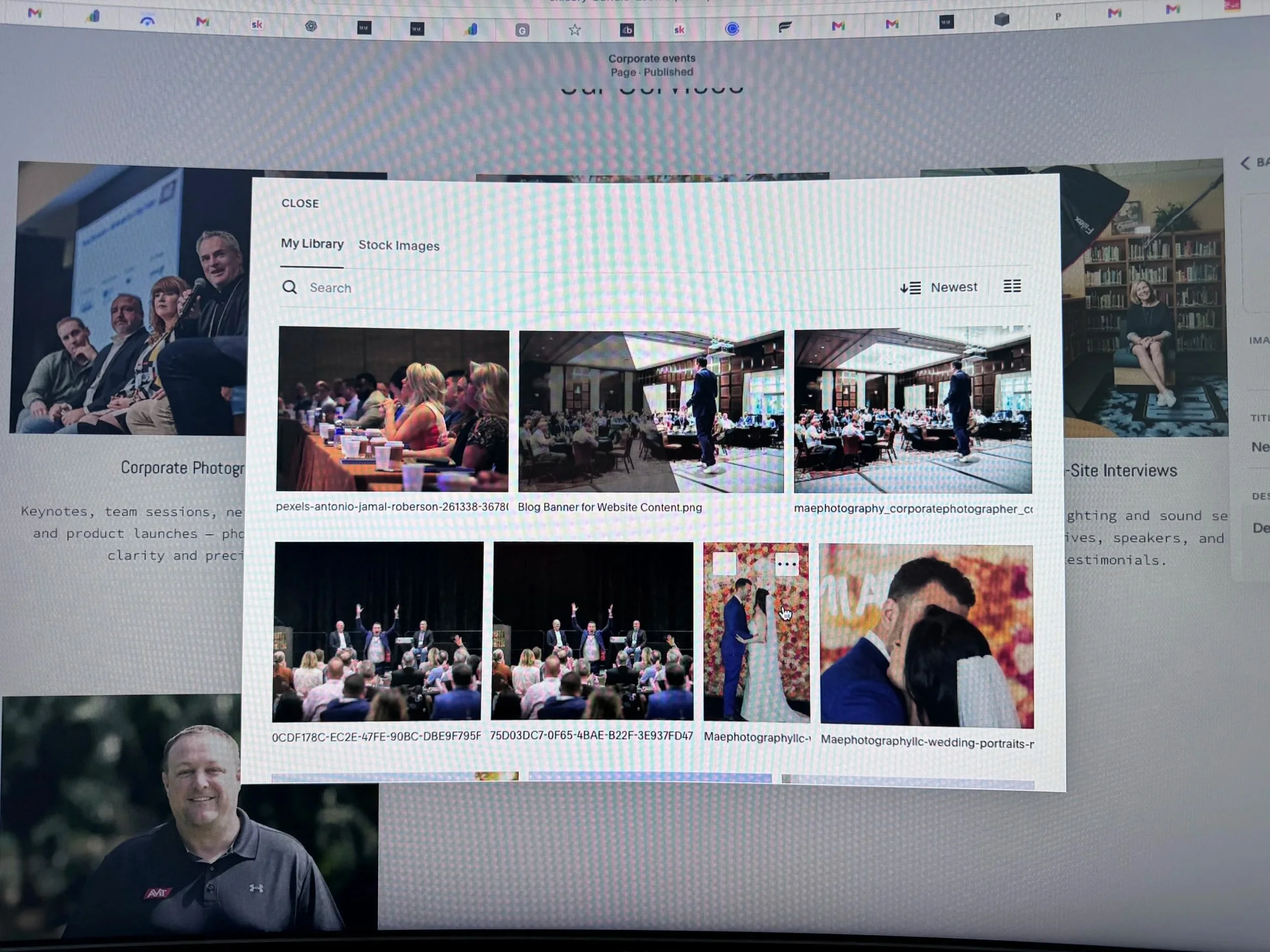 A computer screen displaying a photo library with images from a conference or event, including people sitting at tables, a stage with speakers, and a person holding a microphone.