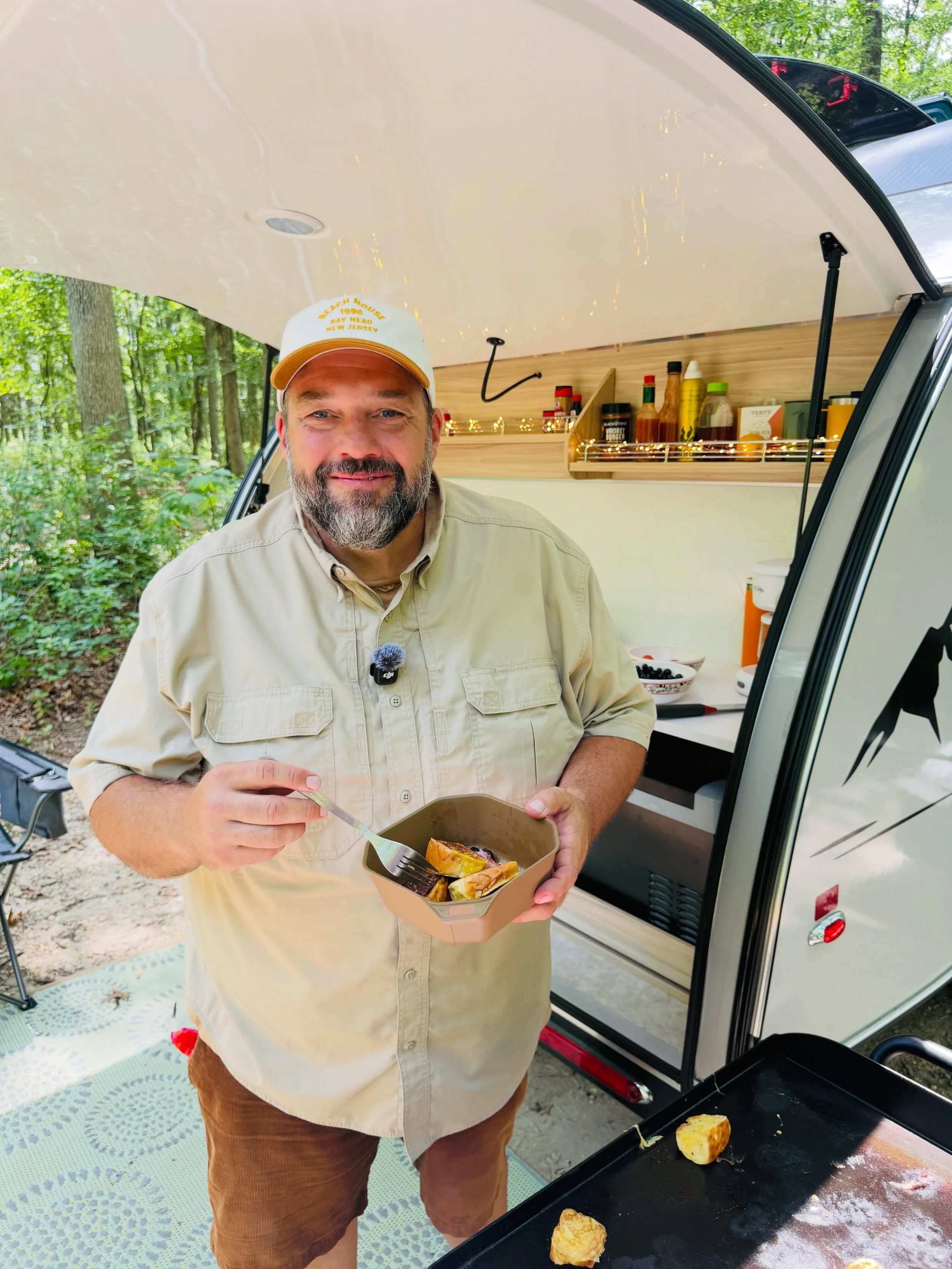 Jeremy Puglisi of RV Atlas standing by his outdoor kitchen of his Nucamp Trailer