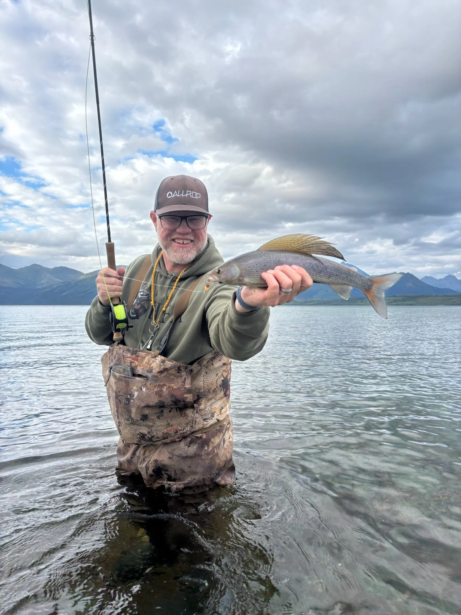 Land Tawney fly fishing in a river.