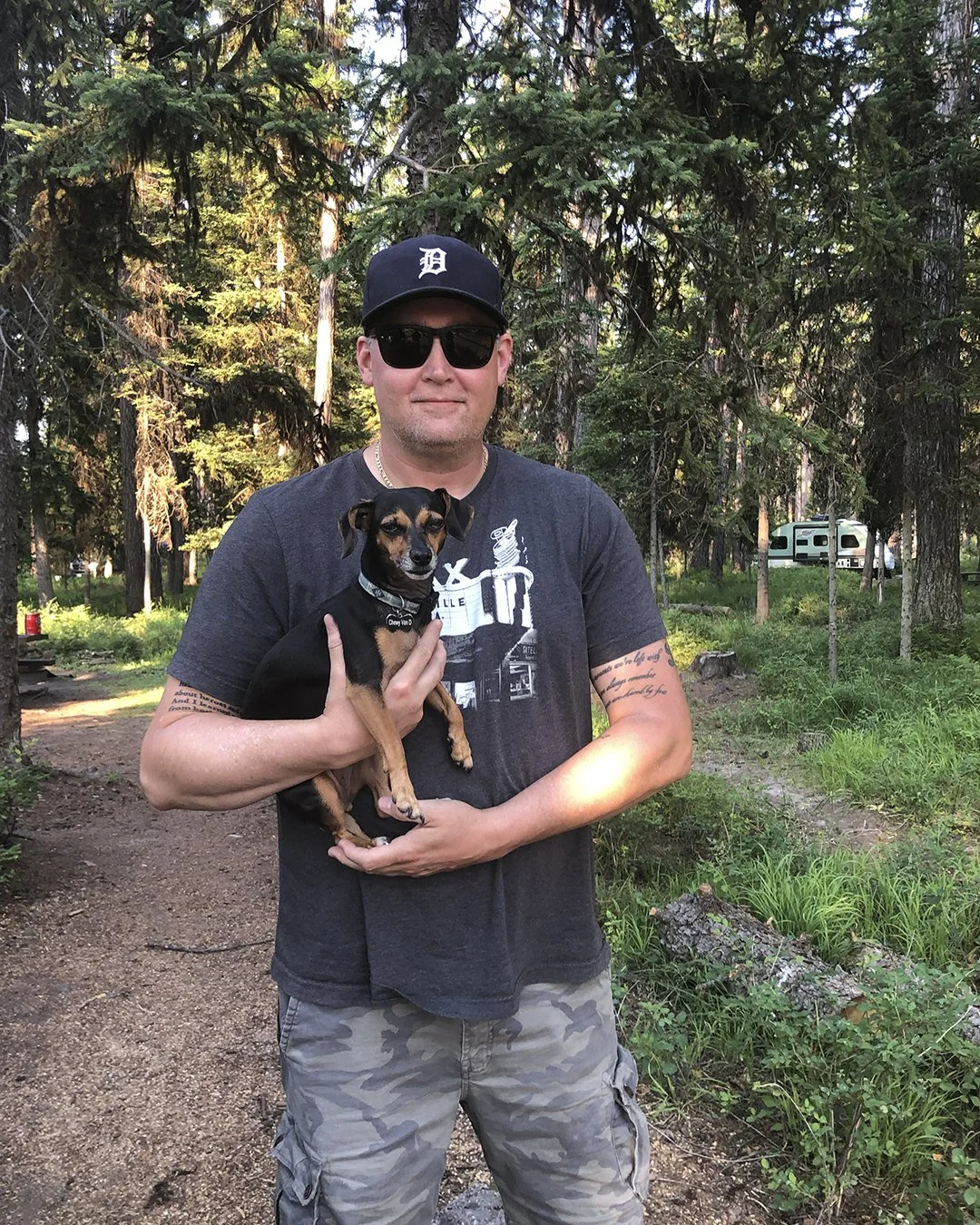 Paul Boomhower holding a dog in the campground