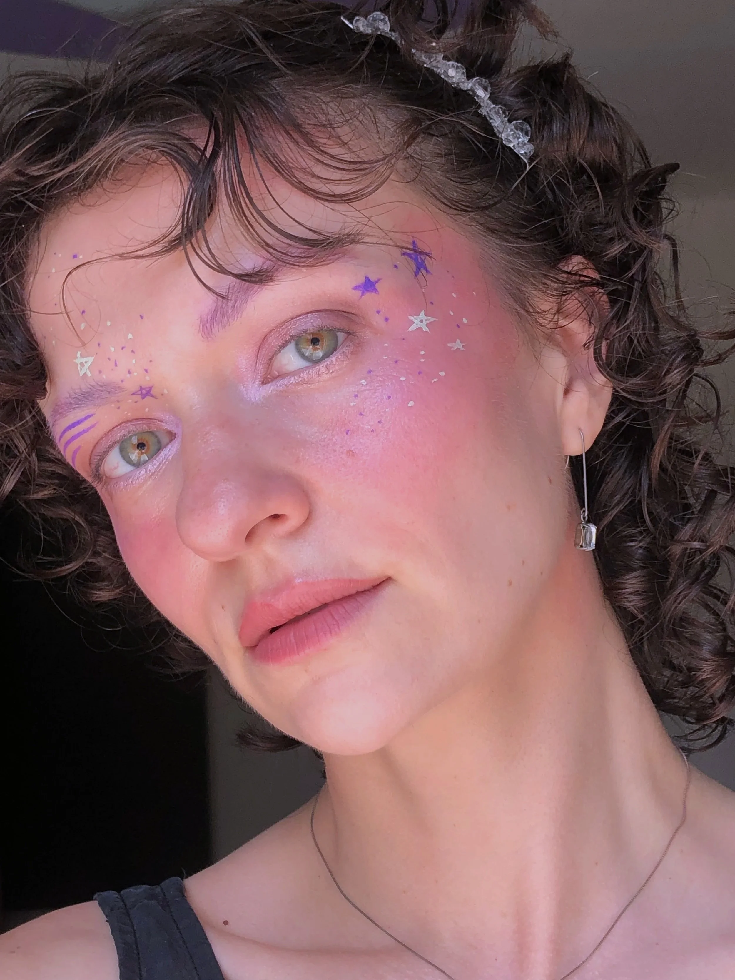 a nonbinary psychic with celestial makeup on