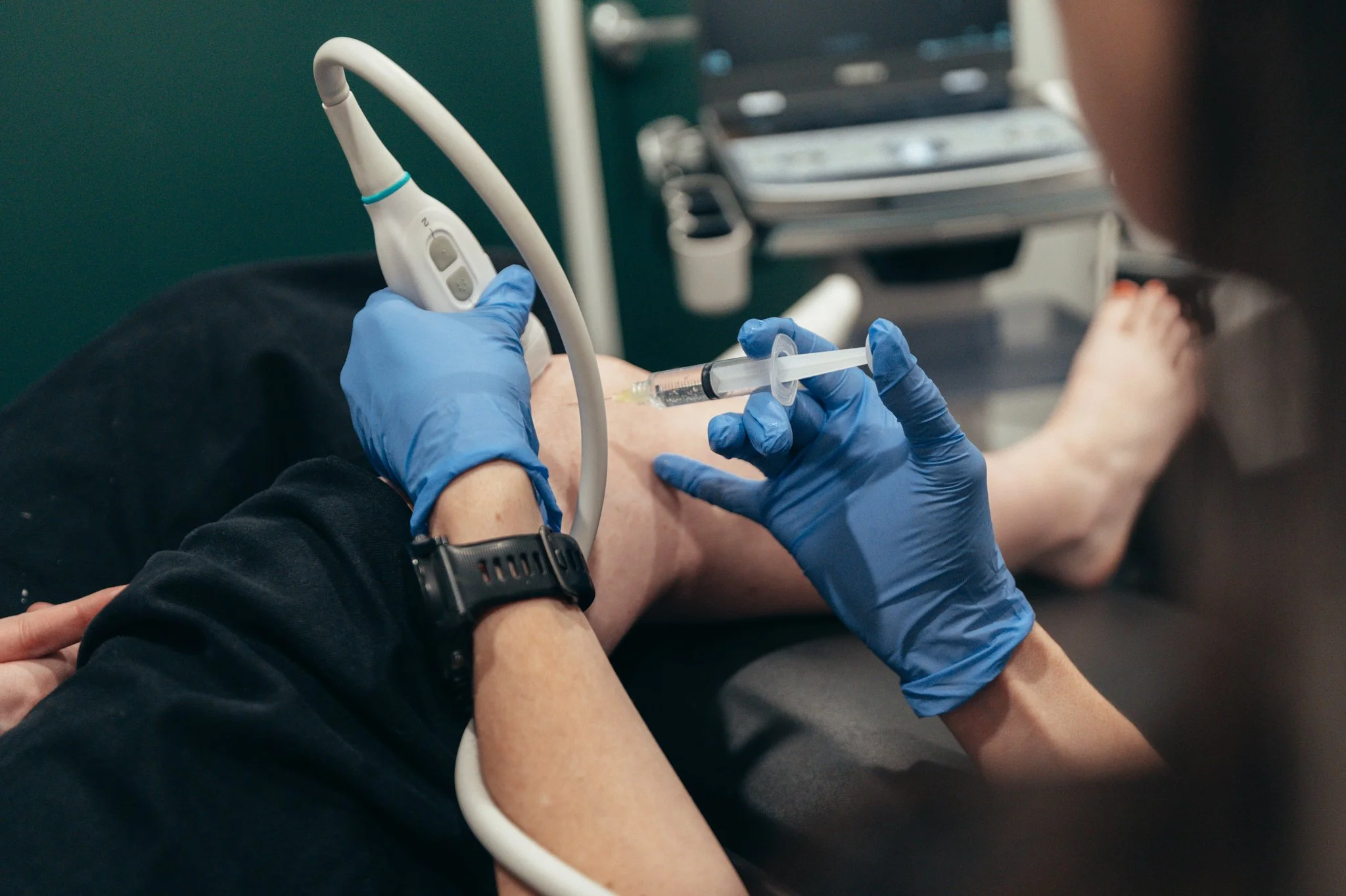 Naturopathic doctor giving ultrasound guided Injection therapy
