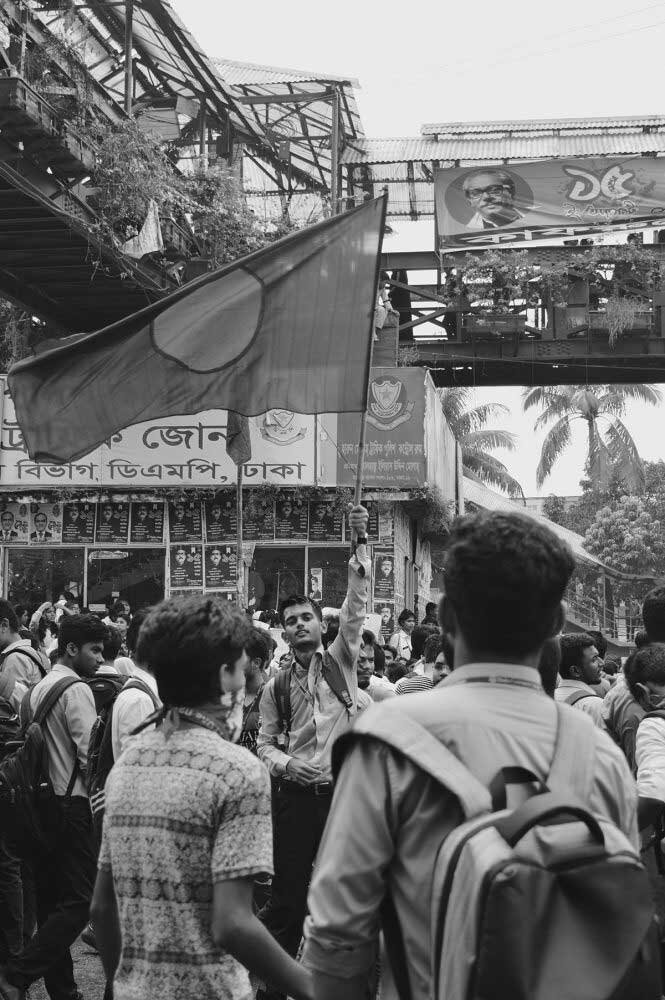   A high school student raises the national flag.  