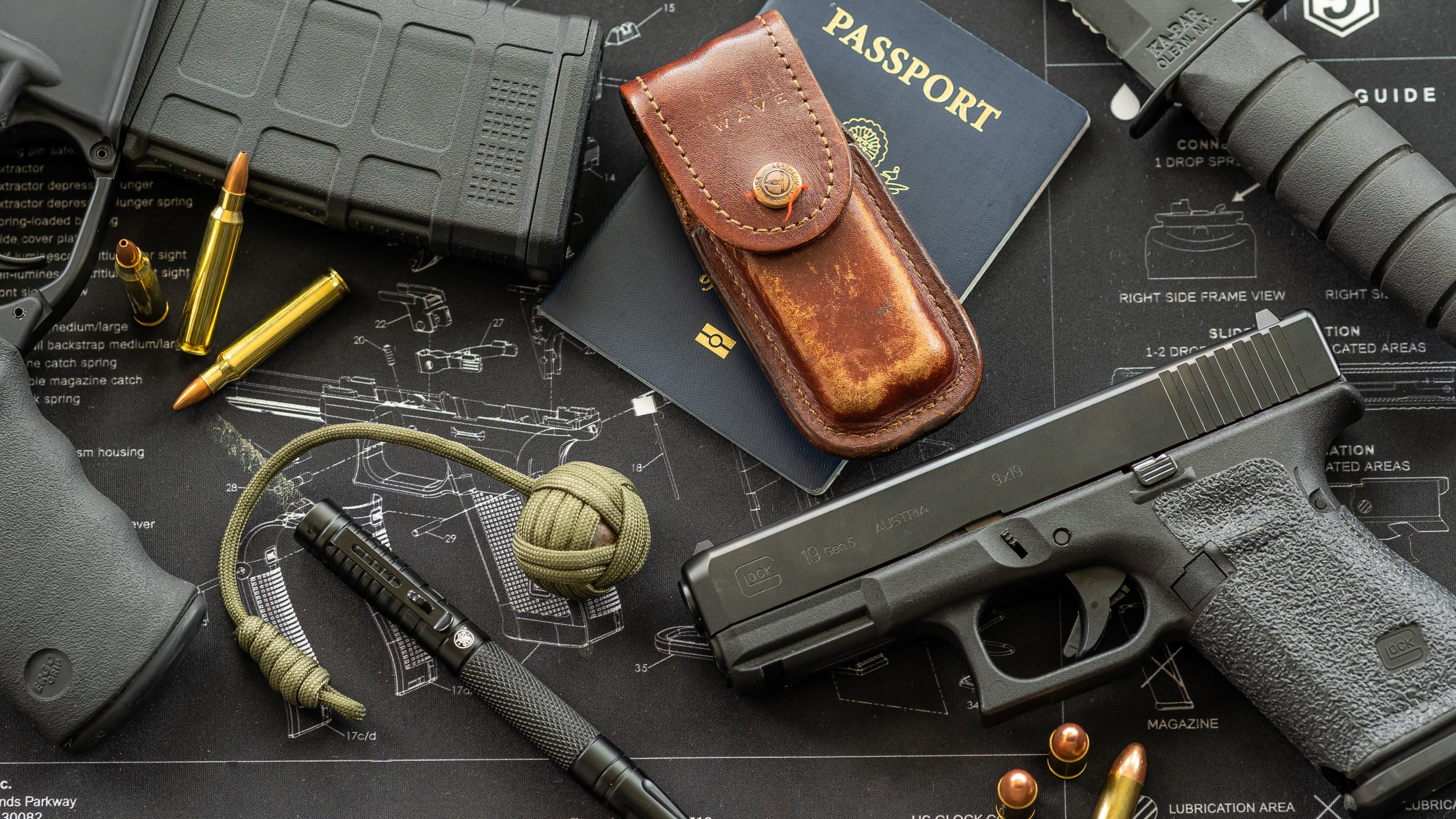 A Glock 19 Gen 5 handgun, a black gun case, a leather gun holster, a passport, bullets, a grenade knot, a tactical flashlight, and a pen are arranged on a gun schematic diagram.