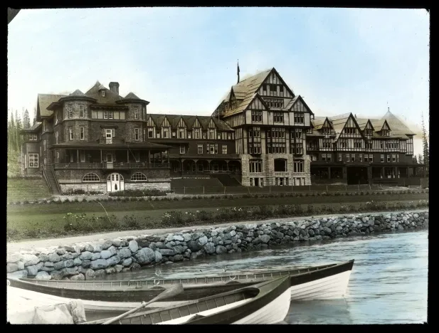   Hand-painted lantern slides, like this one, have come to be synonymous with Mary Schäffer. The elegant Lake Louise Hotel along the banks of the lake itself, near then-called Laggan Station. 1899 – [ca. 1910]    Courtesy of the Whyte Museum of the C