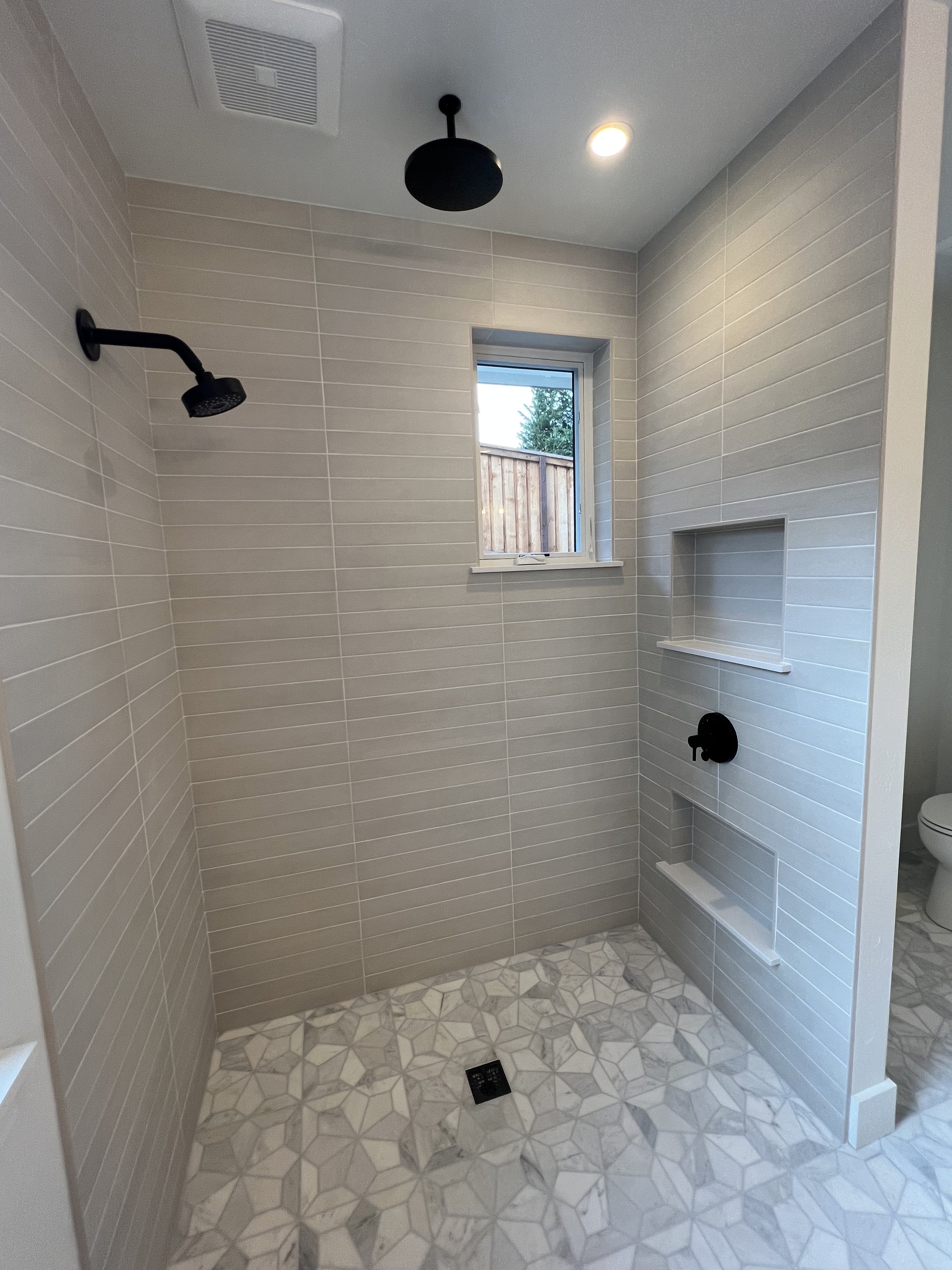 Shower tiled wall and floor with shampoo niches