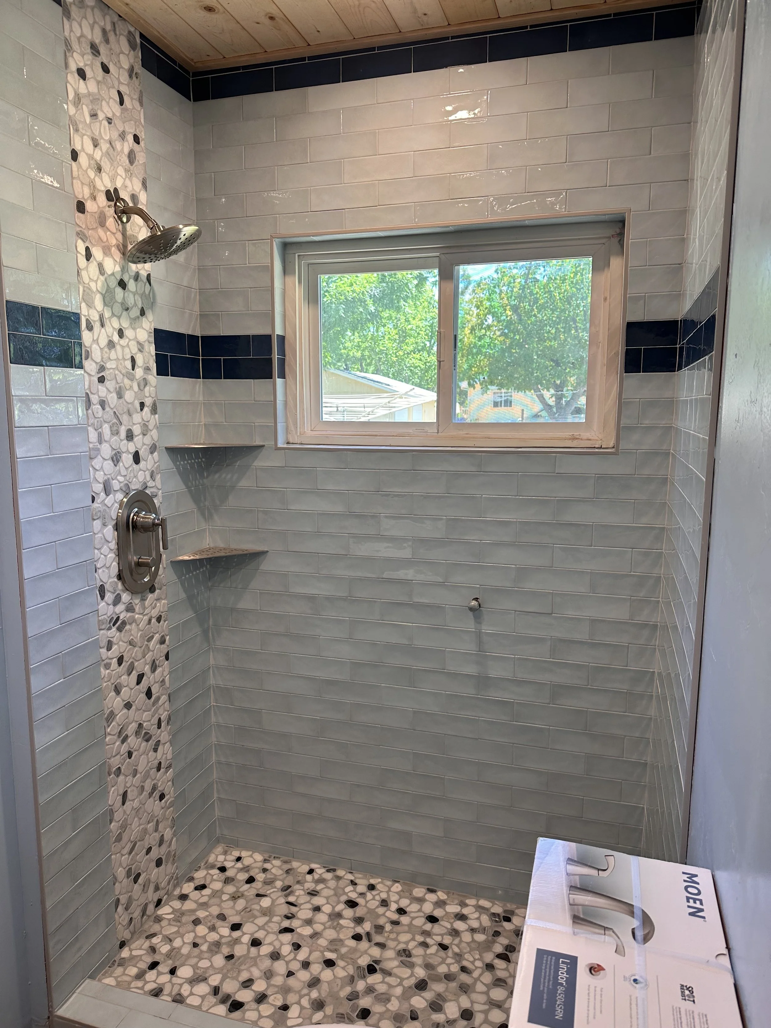 Tiled shower enclosure featuring a waterfall layout.