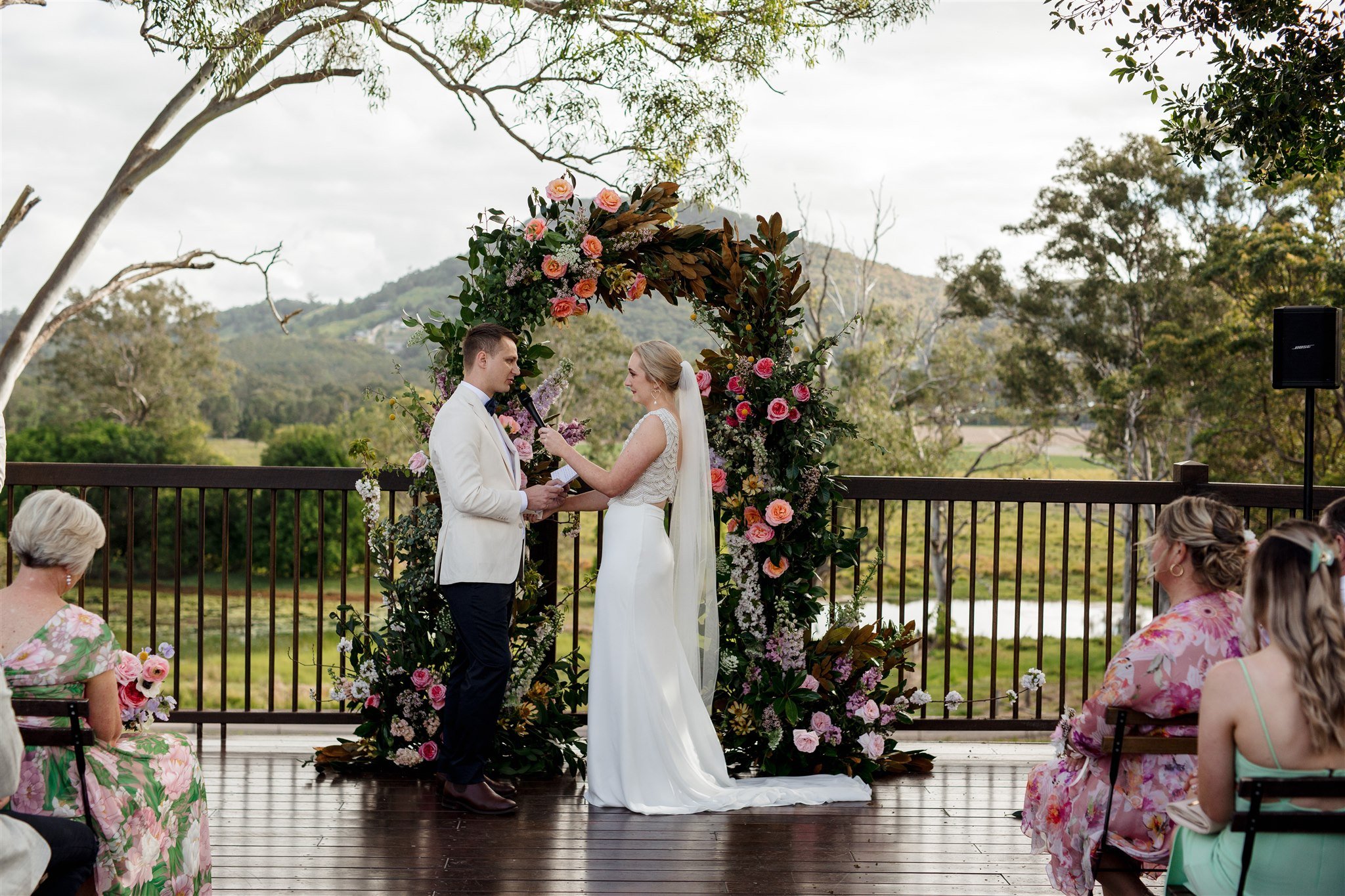 Wedding Florist Sunshine Coast - a couple saying their vowels in front of a full flower arch