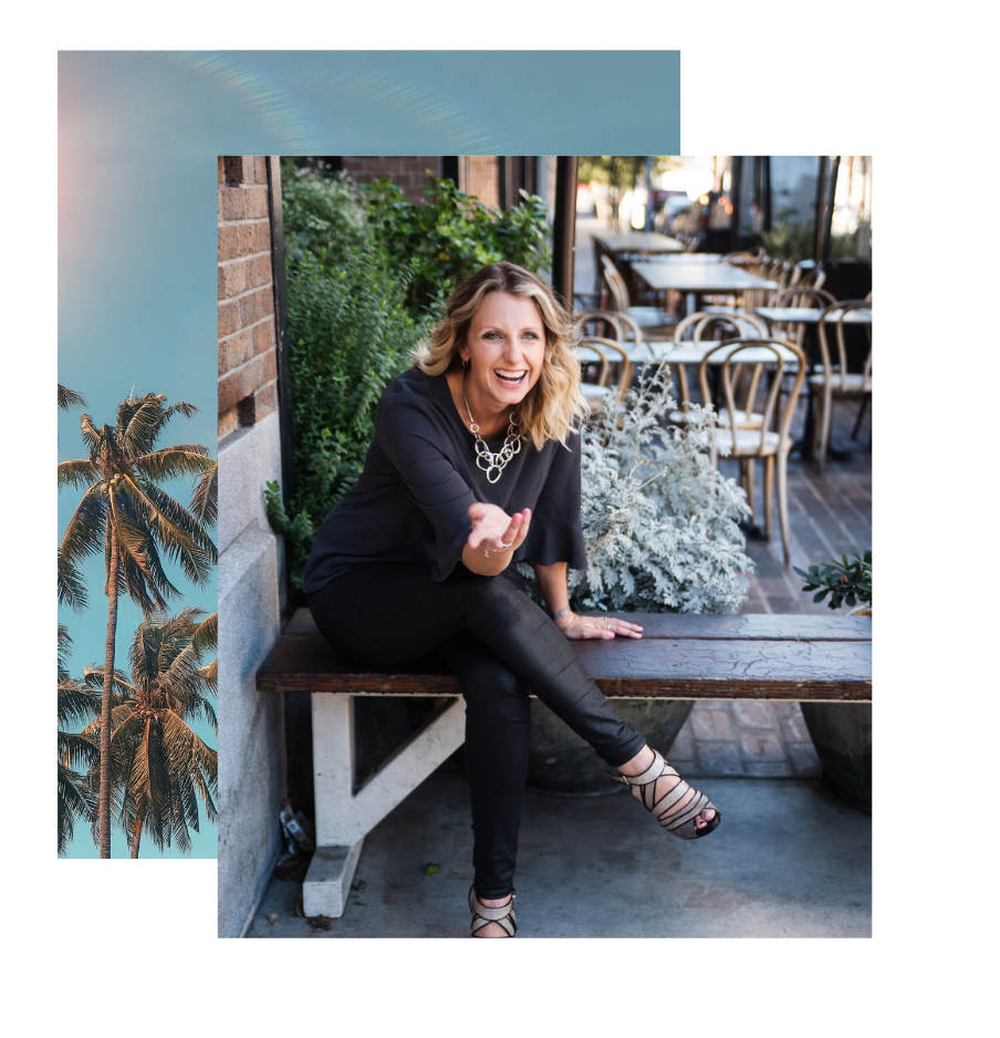 A smiling woman with blonde hair sits on a bench outside a cafe, wearing a black outfit and strappy heels, with tables and chairs in the background.