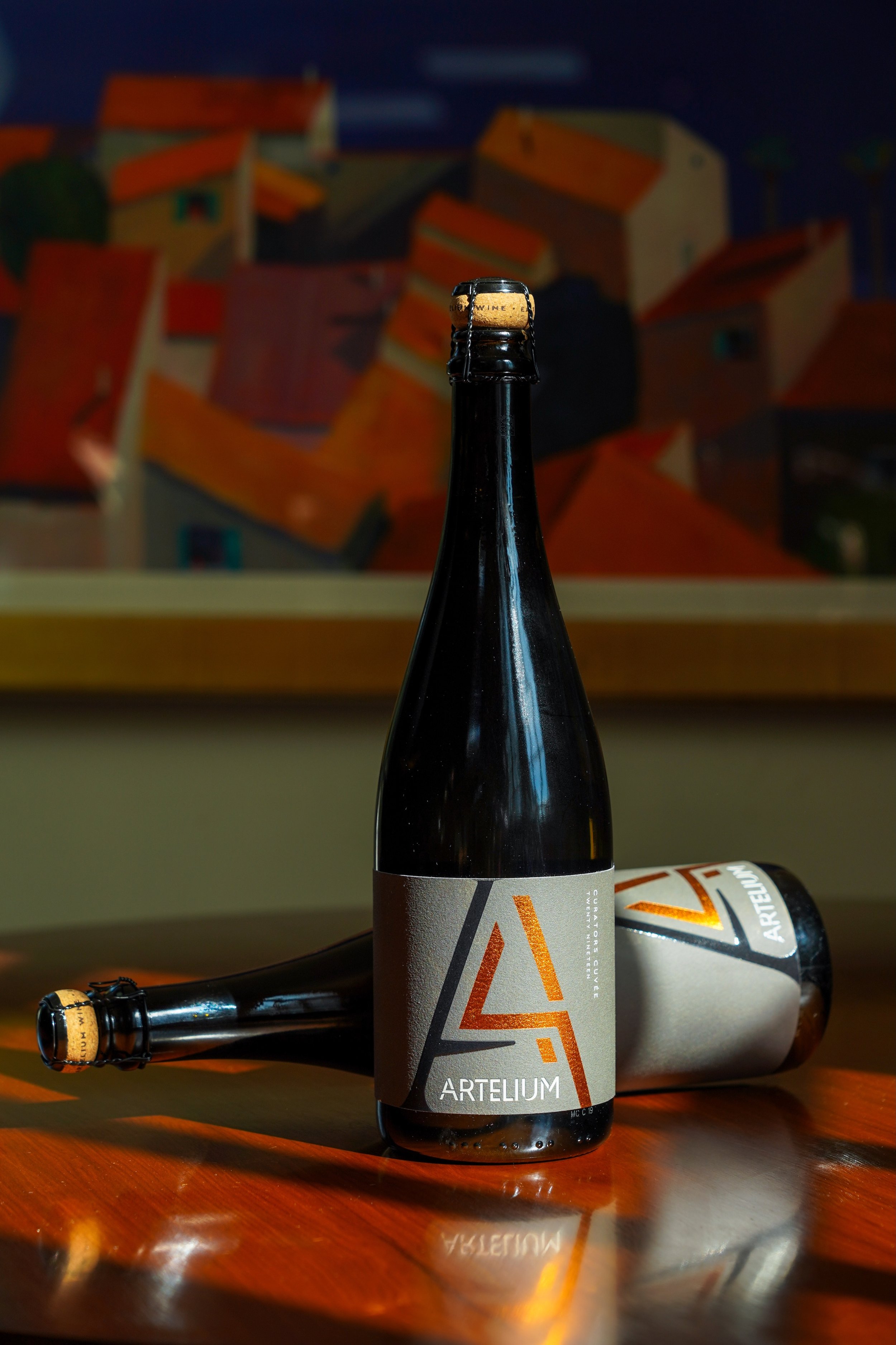 Artelium curators cuvée on dark table with light streaming in 