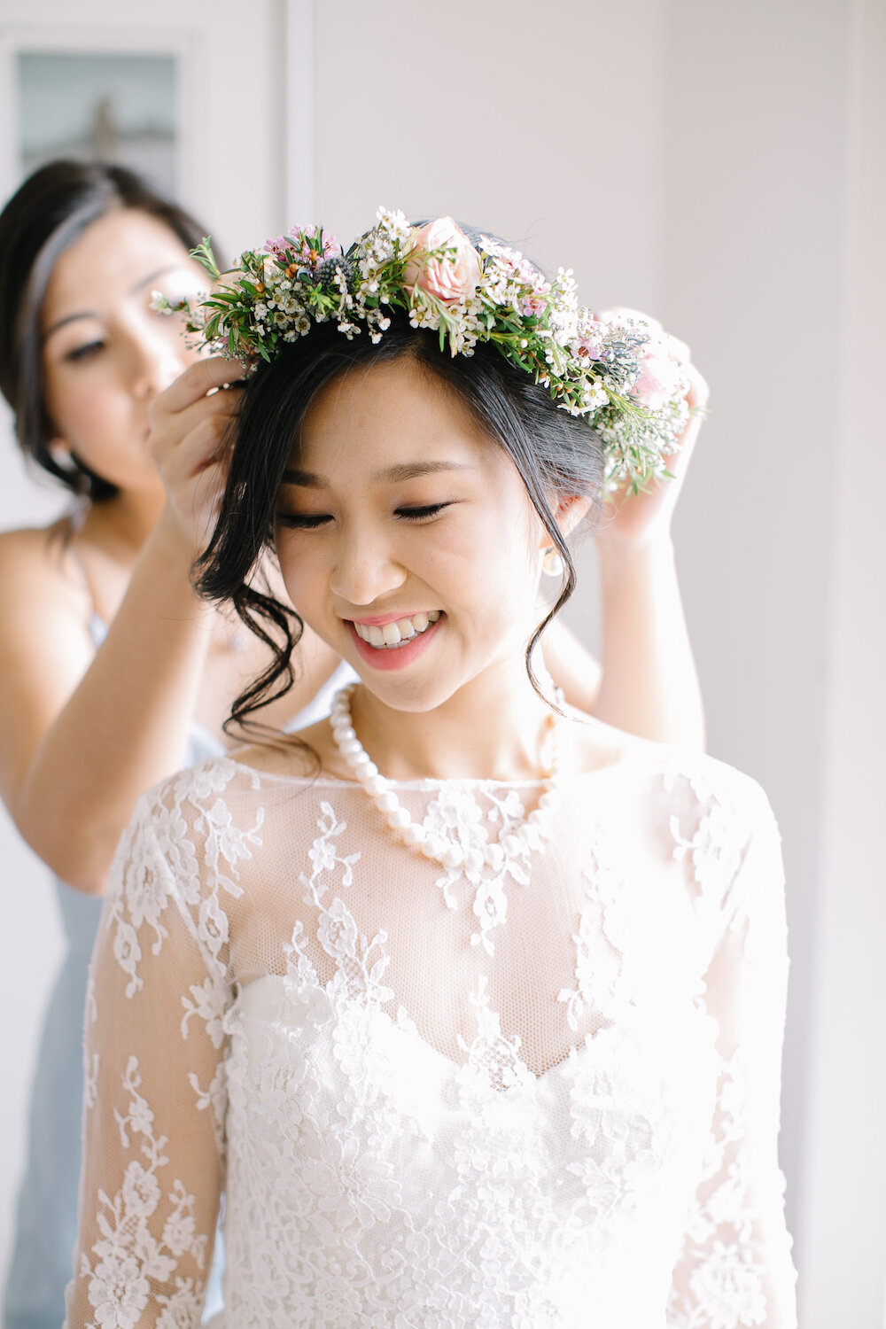 bride getting ready with flower crown wearing reem acra dress