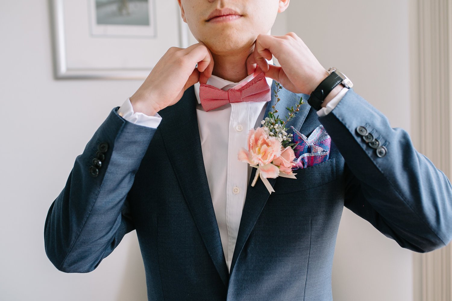 groom suiting up with tulip buttonhole