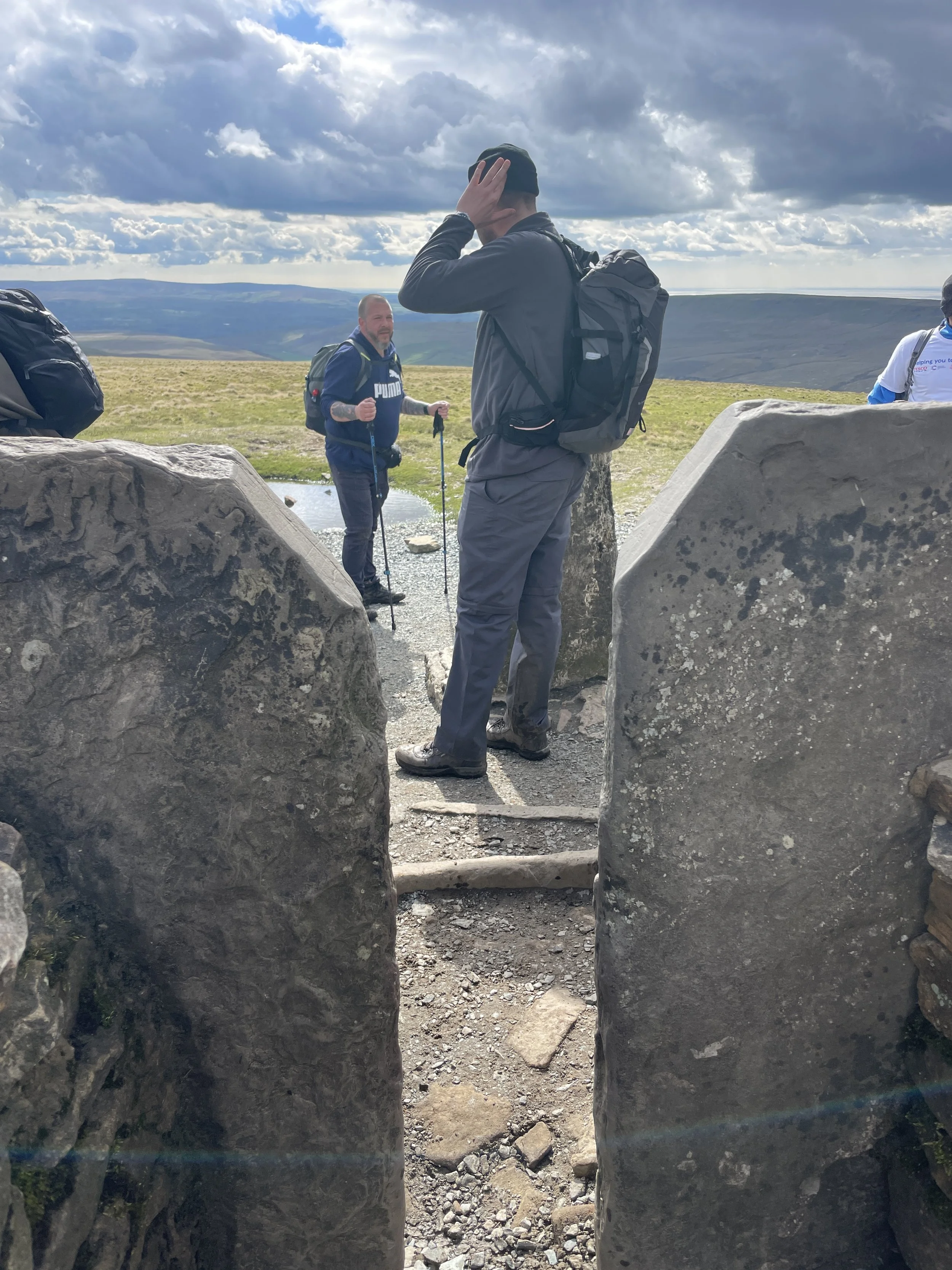 hikers on the summit of whernside on the yorkshire three peaks challenge with yonder adventure company