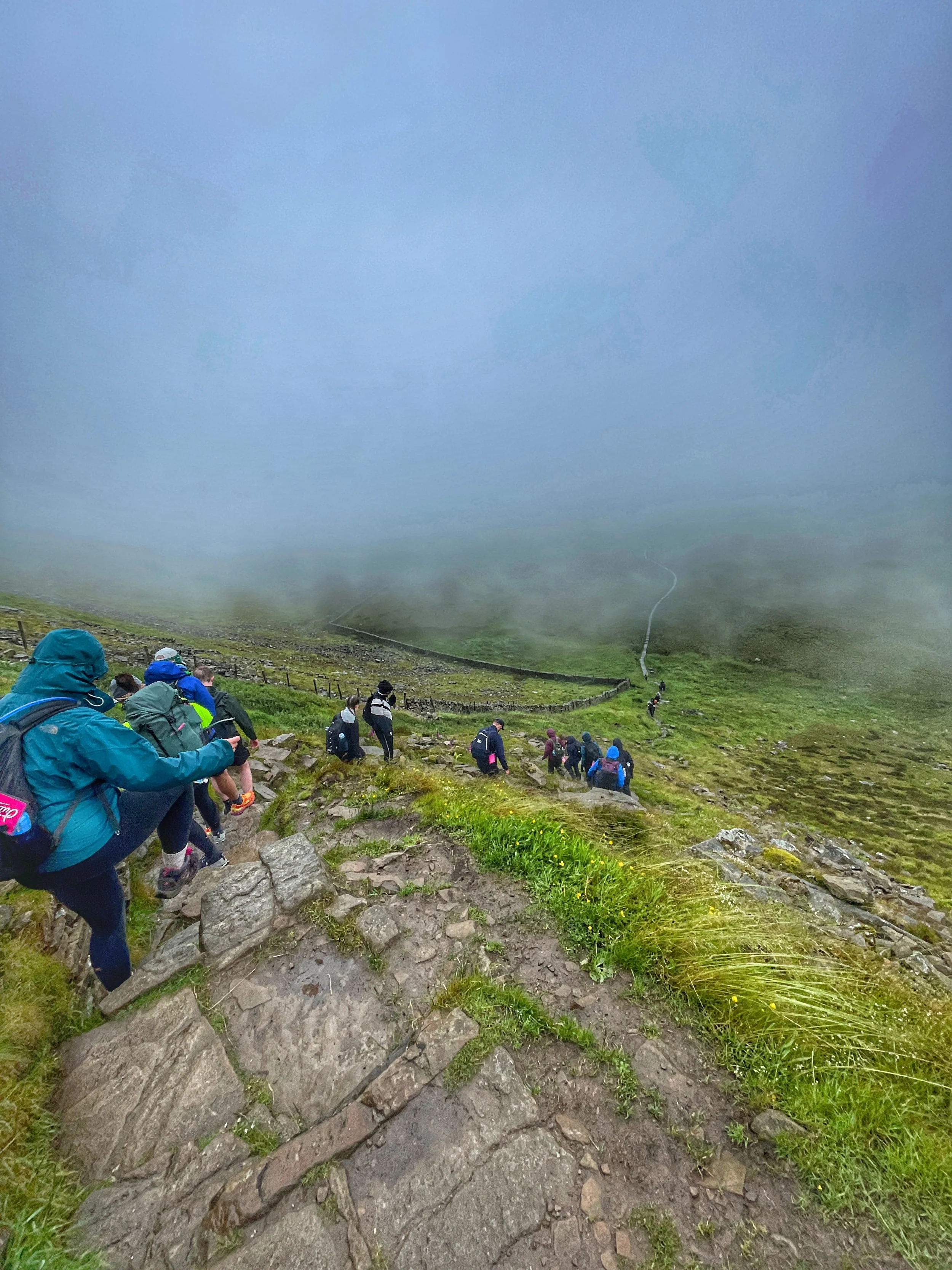 hikers descending ingleborough during the yorkshire three peaks challenge with yonder adventure company